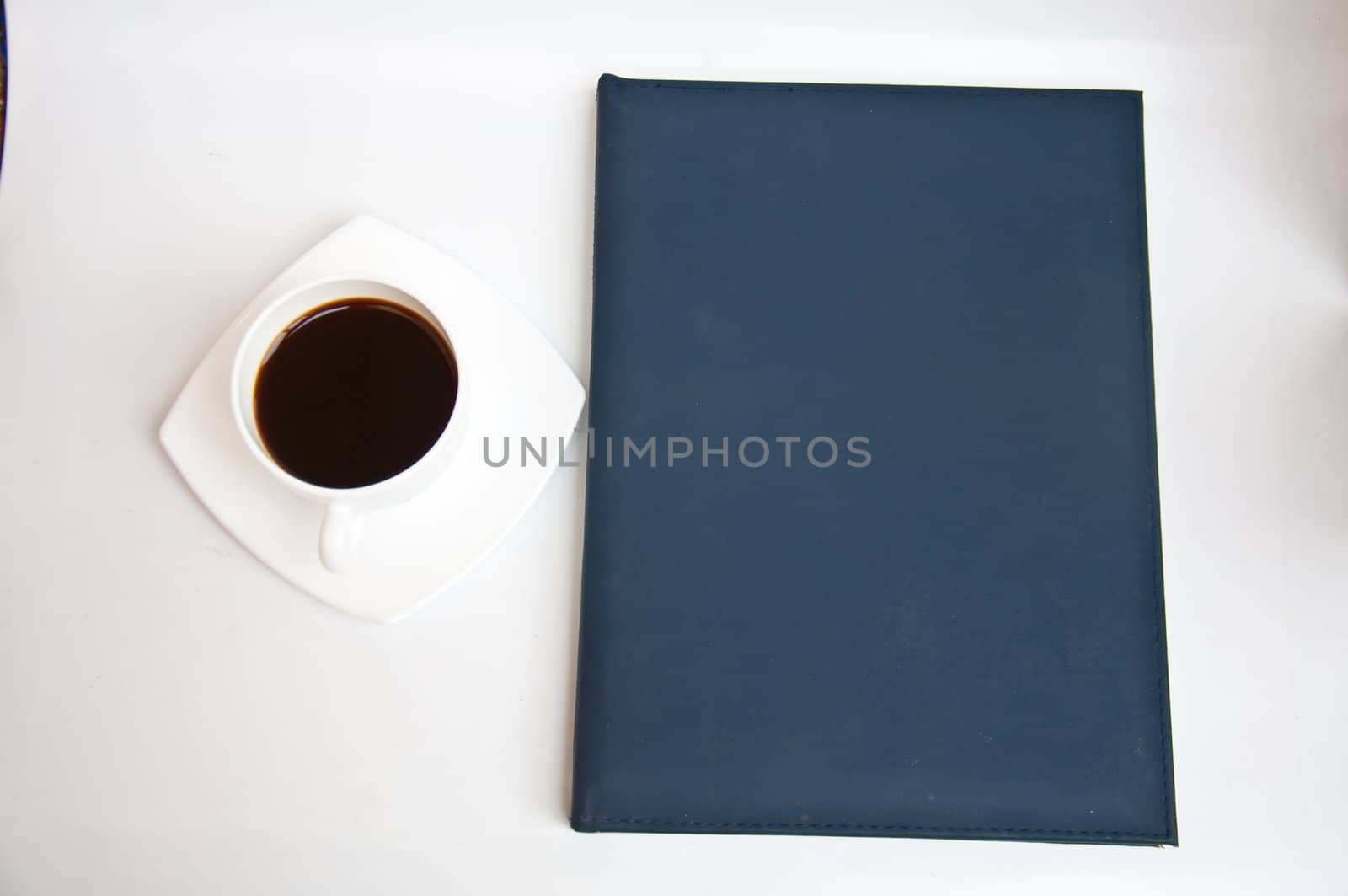 black coffee and blank notebook on white background