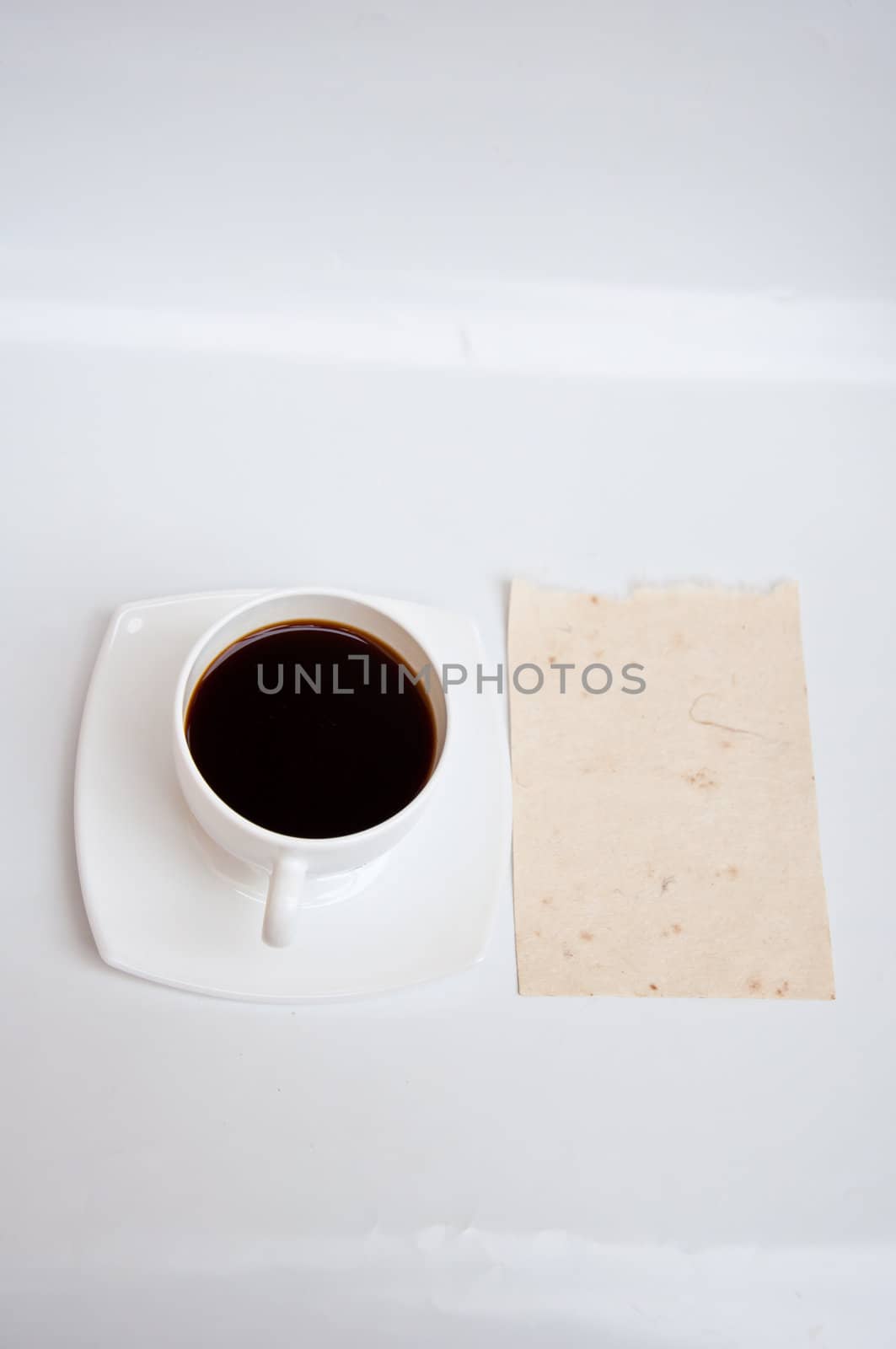 Blank paper and black coffee on white background