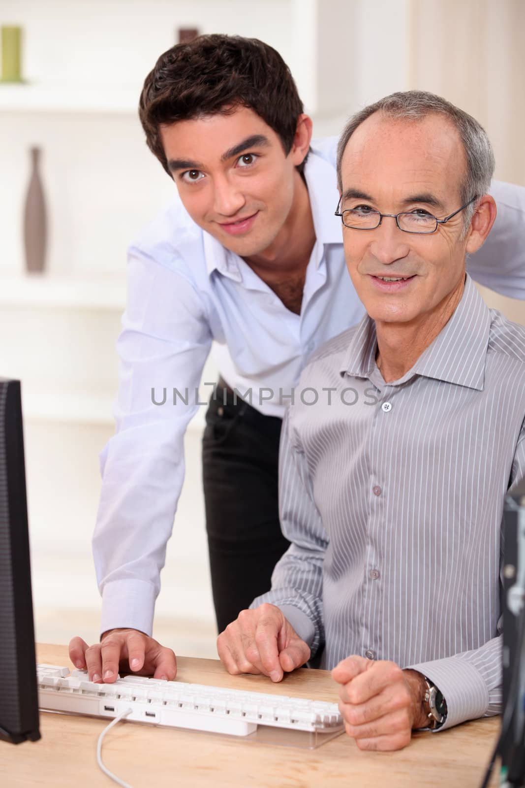 A father and his son looking at a computer.