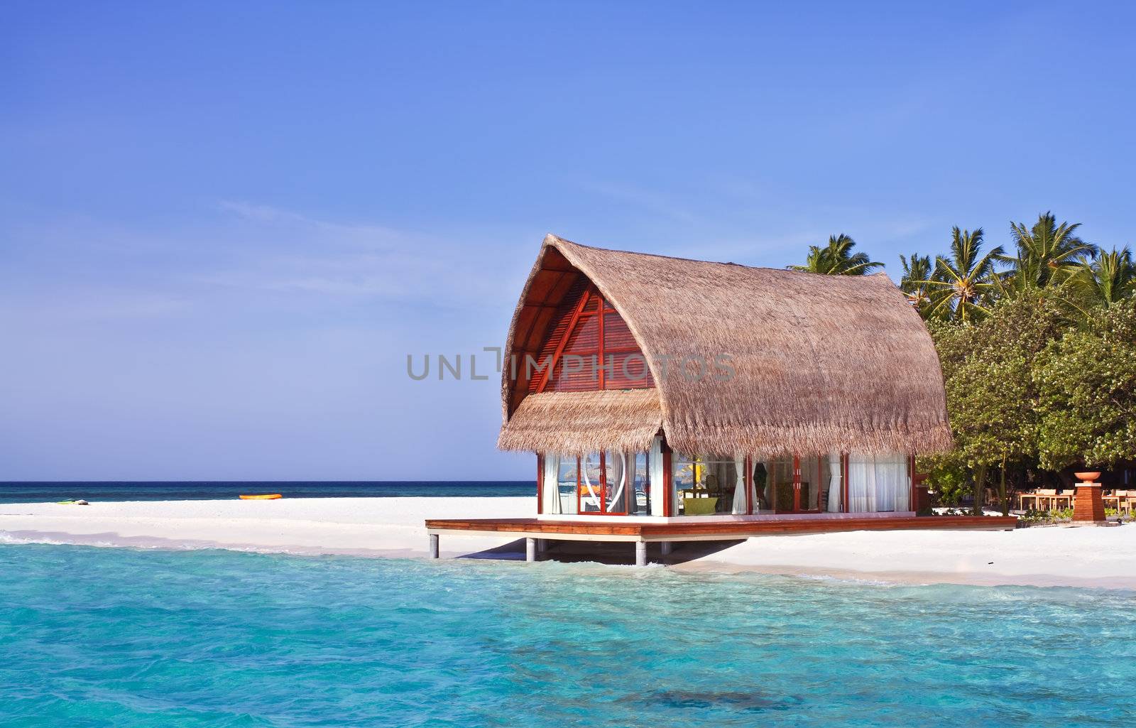 Landscape photo of beach house in Maldive ocean with blue sky