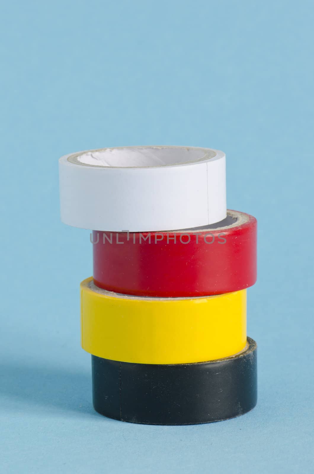 Colorful sticky tape tool for wire isolation on blue background.