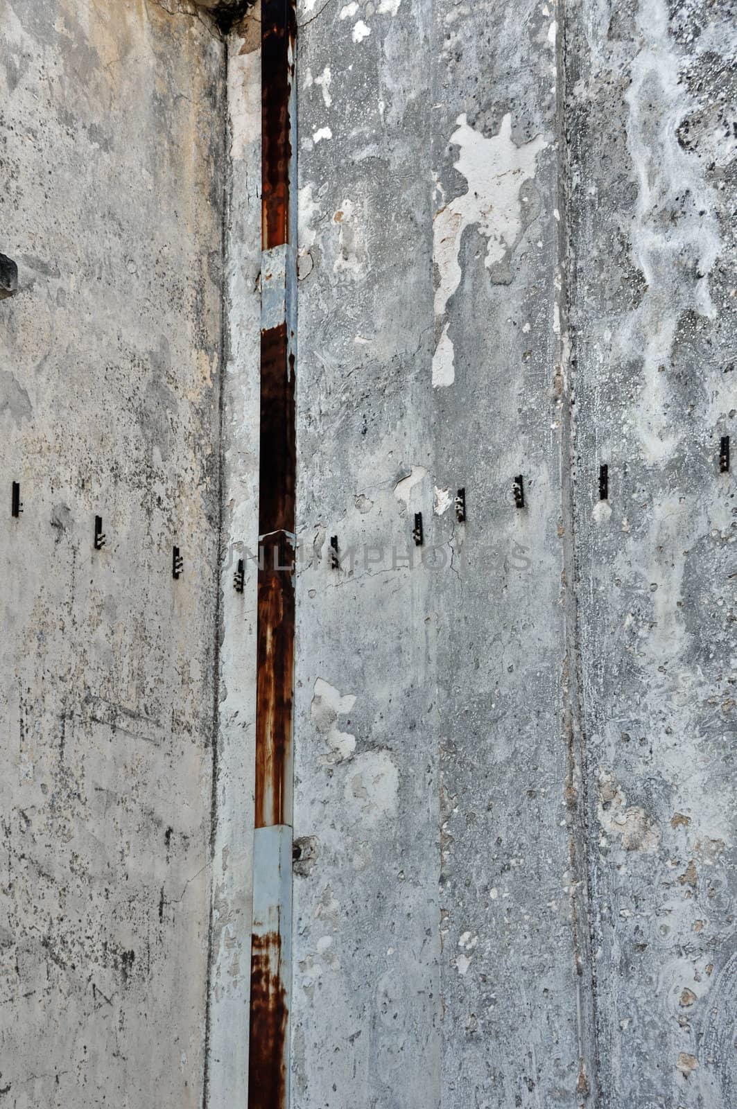 Concrete factory wall and rusty pipe. Industrial background.