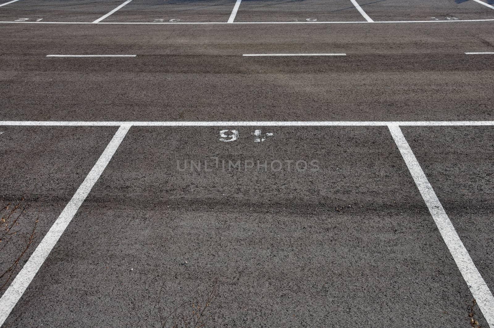 Dividing lines in empty asphalt paved parking lot abstract background.