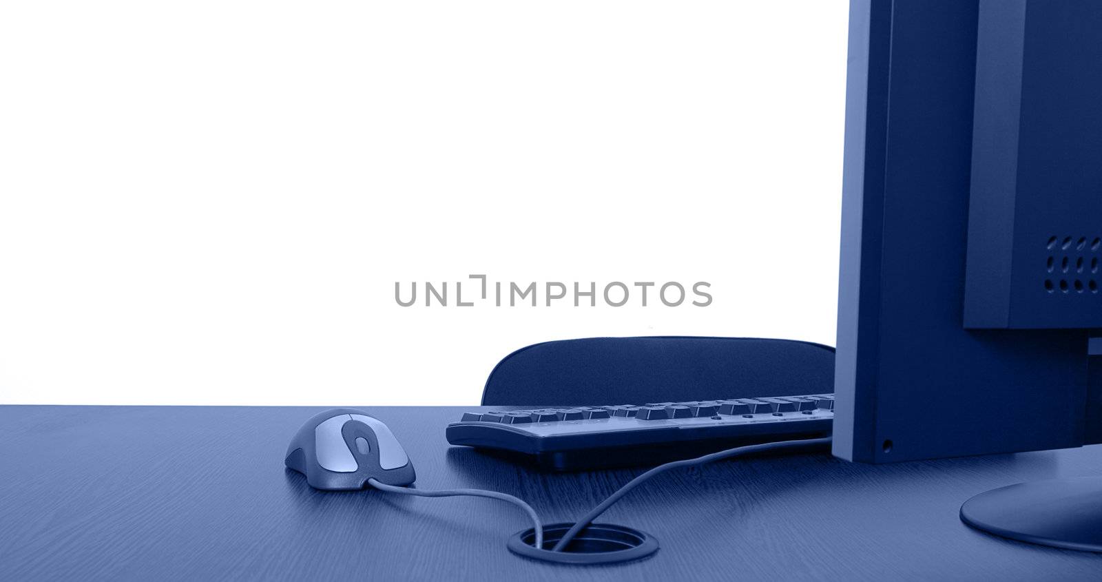 Image of an empty office desk with a lot of copy space behind it on the white wall.