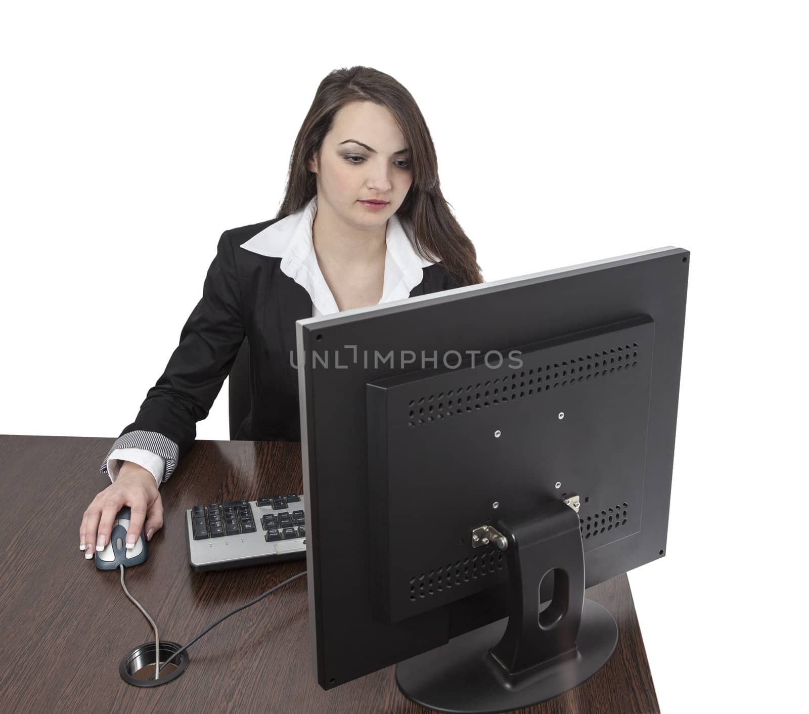 Image of a young brunette woman working on a computer at her desk, isolated against a white background.