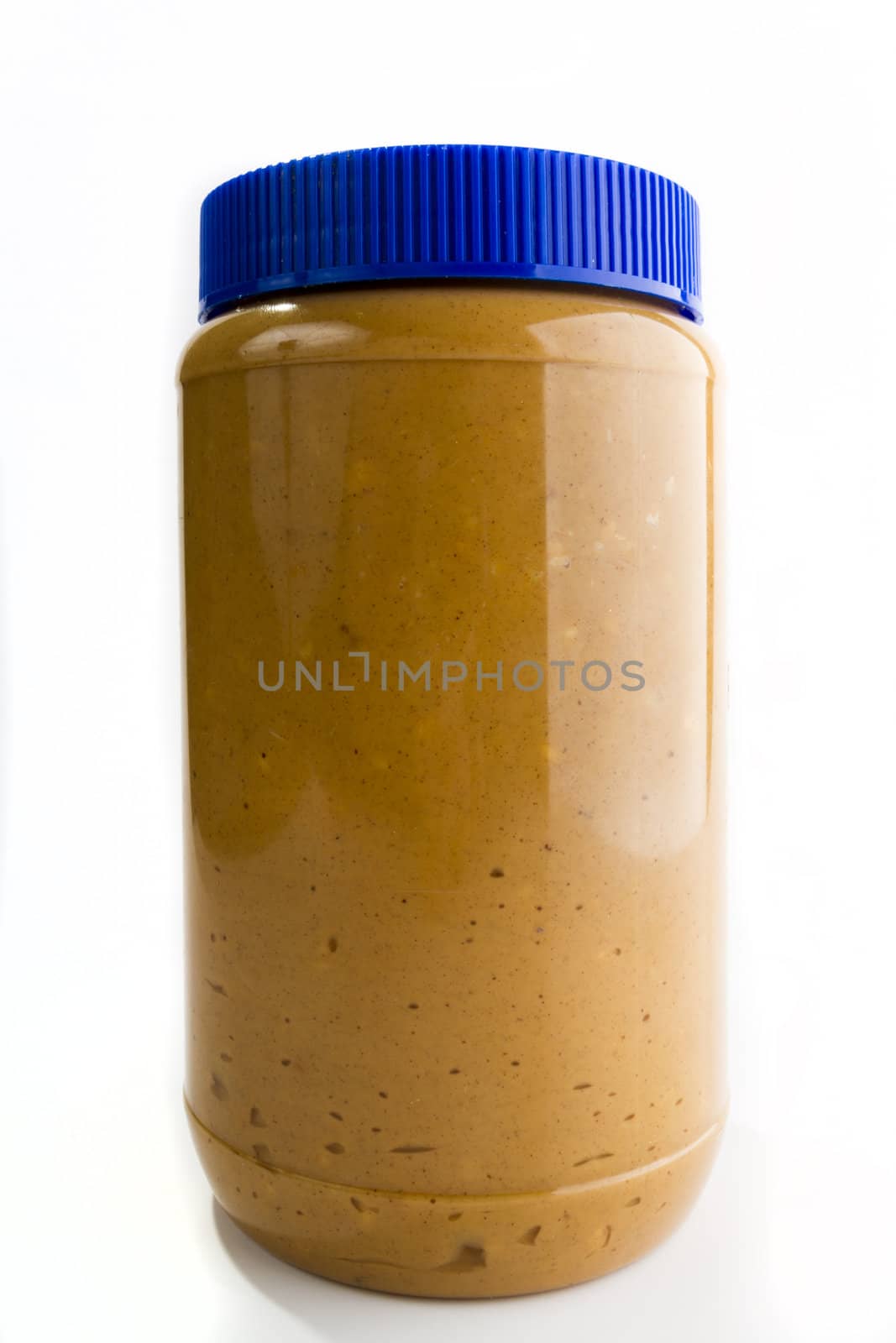 Single tall jar of peanut butter with a highlight reflection on the right side. image is against a light background