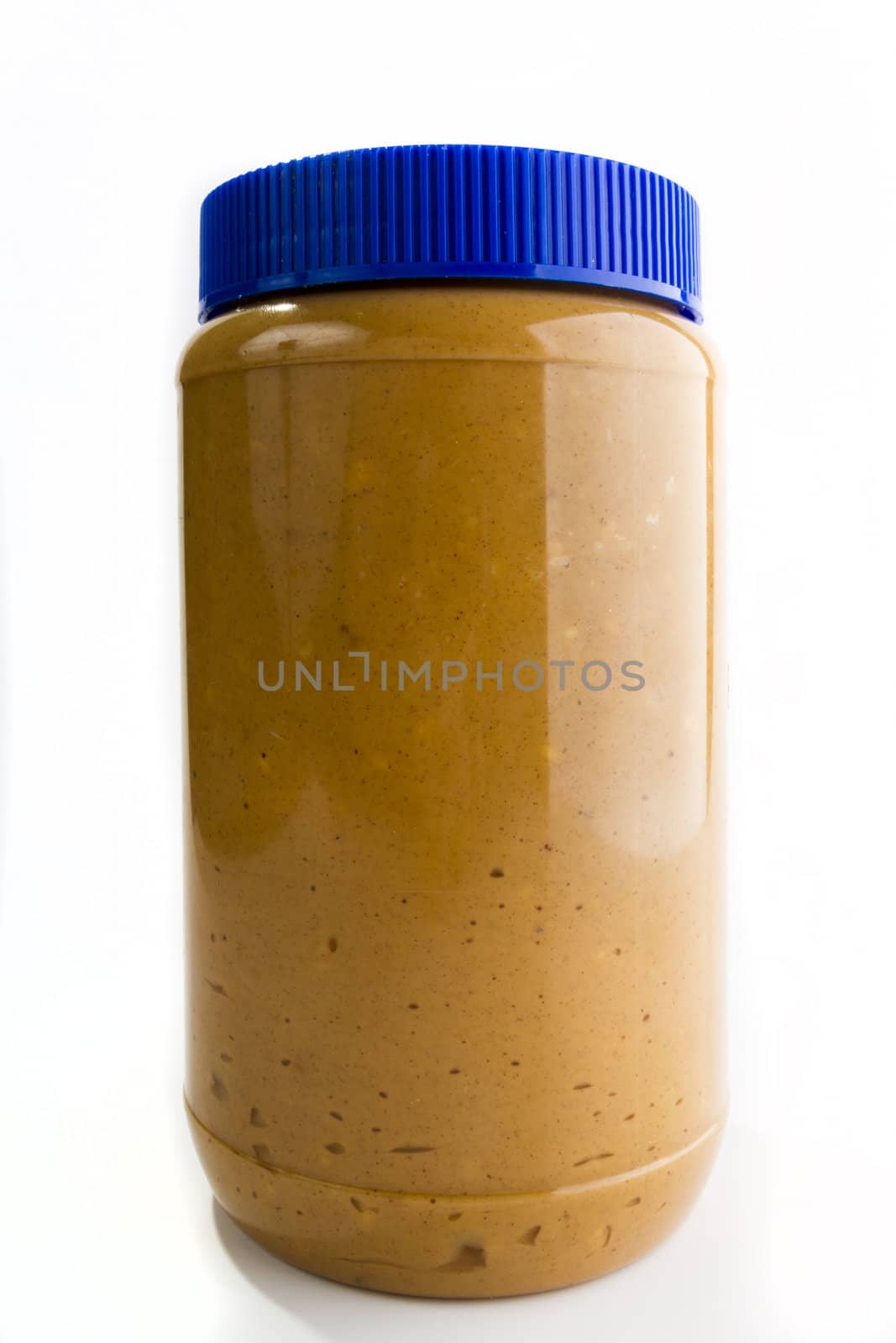 Single tall jar of peanut butter with a highlight reflection on the right side. image is against a light background