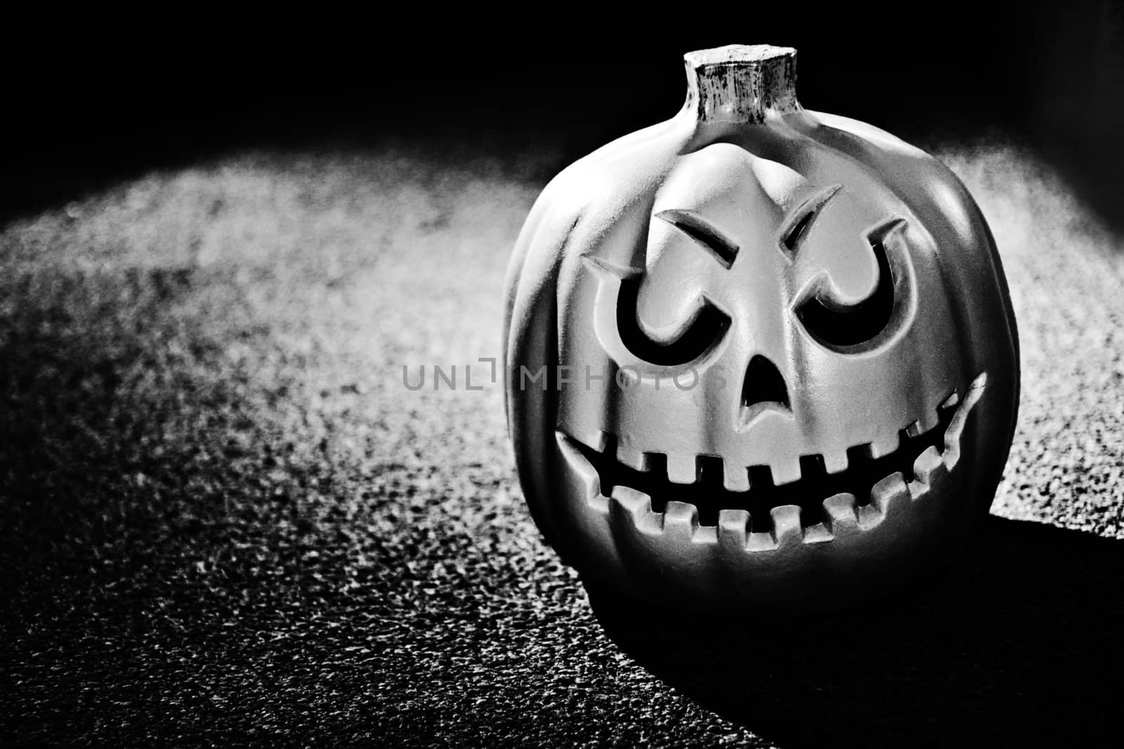 Single pumpking against a heavily textured background in black and white