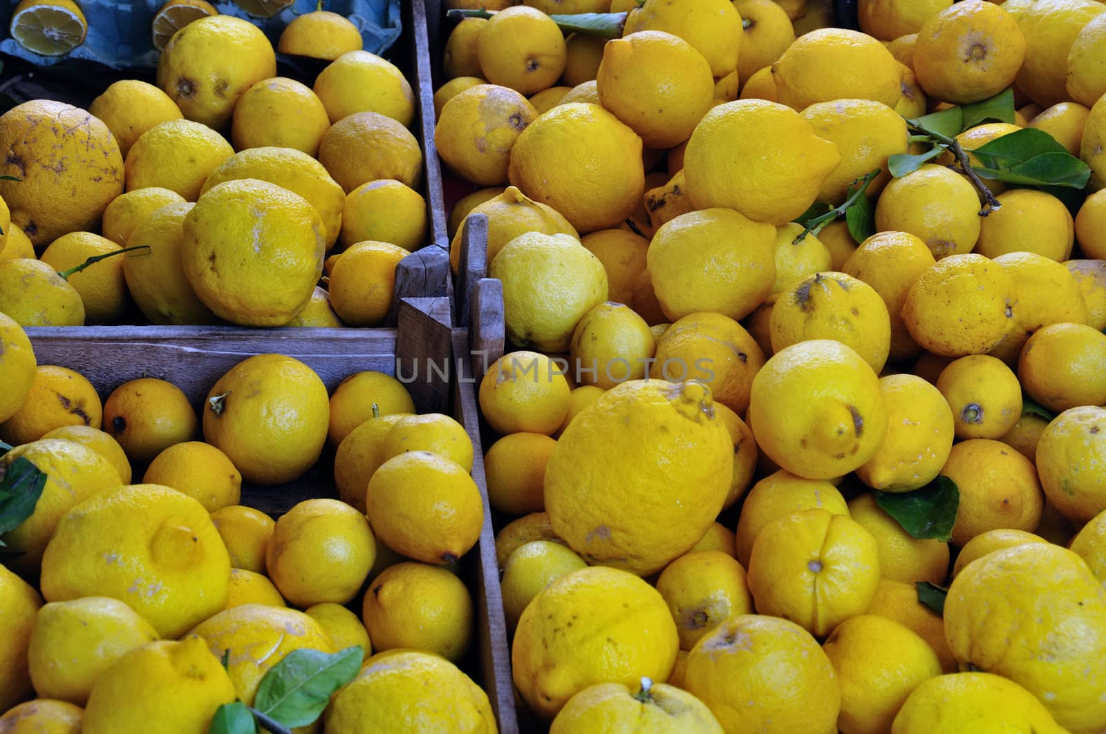 Fresh lemons in wooden crates at grocery store.