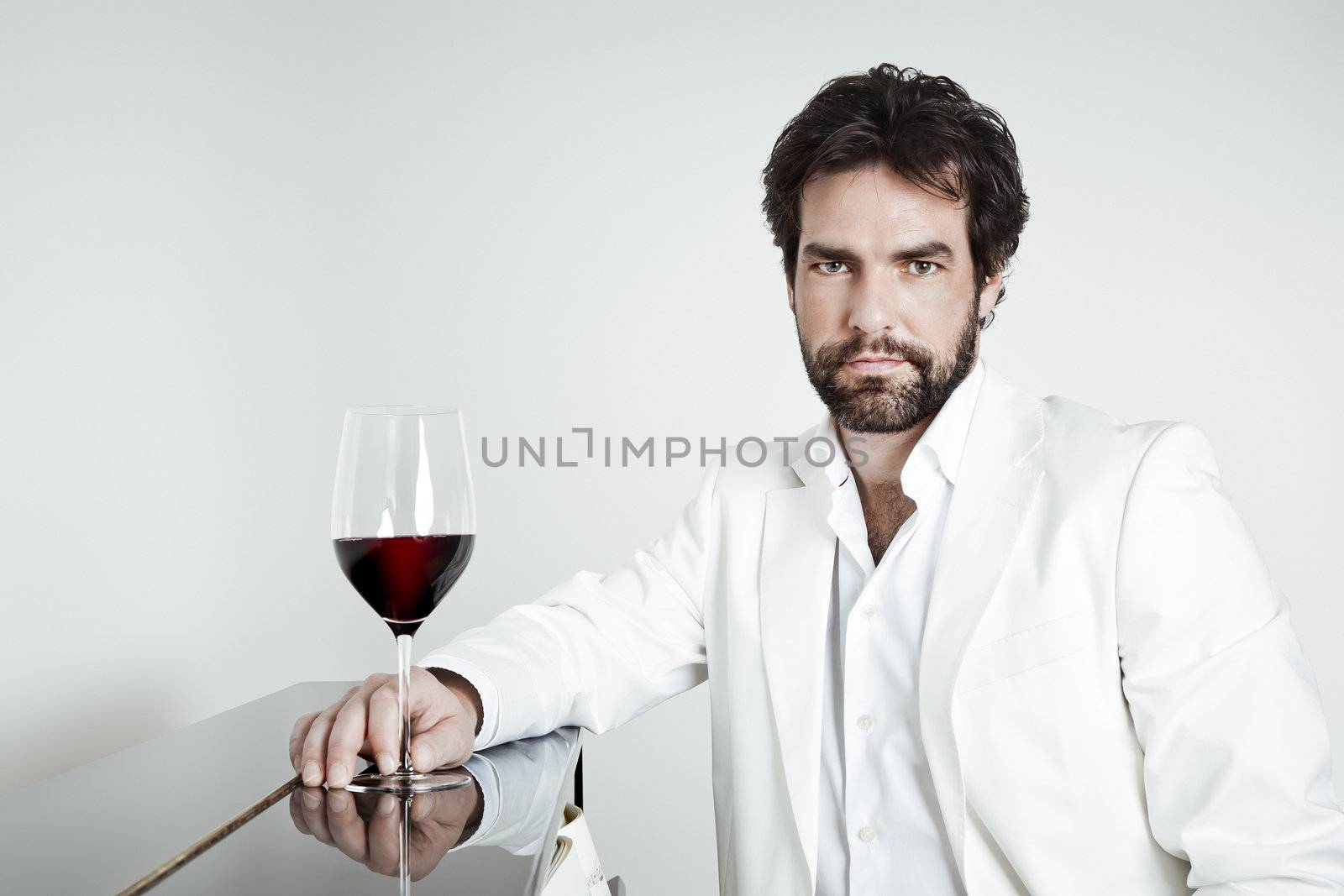 An image of a handsome man and a glass of red wine