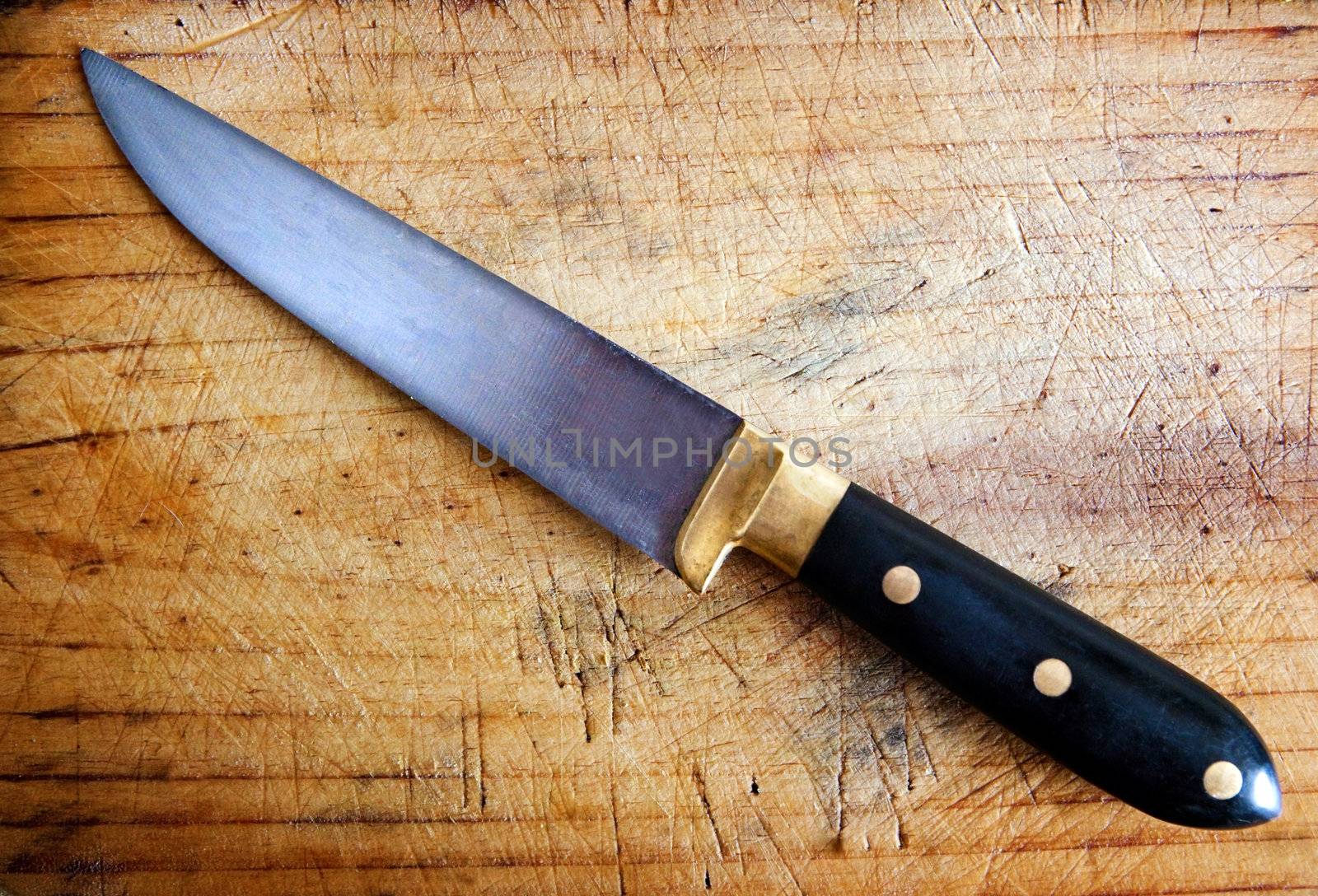 Close up image of kitchen knife with cutting board