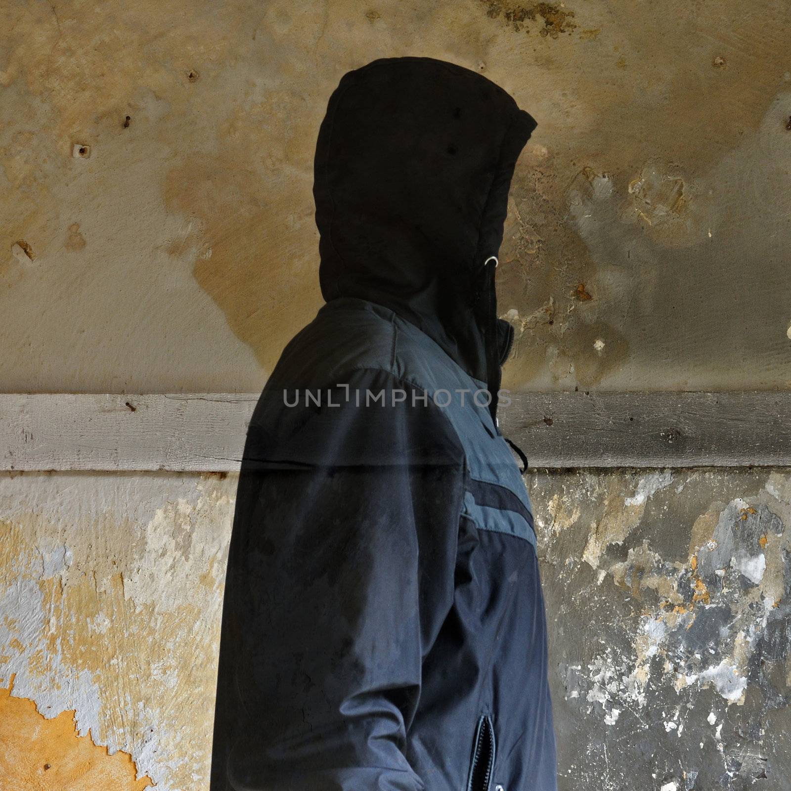 Invisible man against moldy crumbling wall texture in abandoned interior.