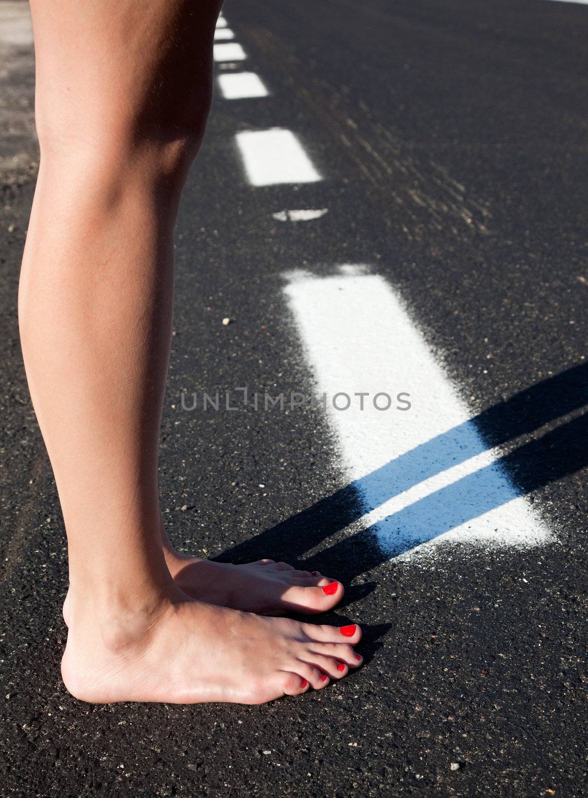 Barefoot woman in a road by carloscastilla