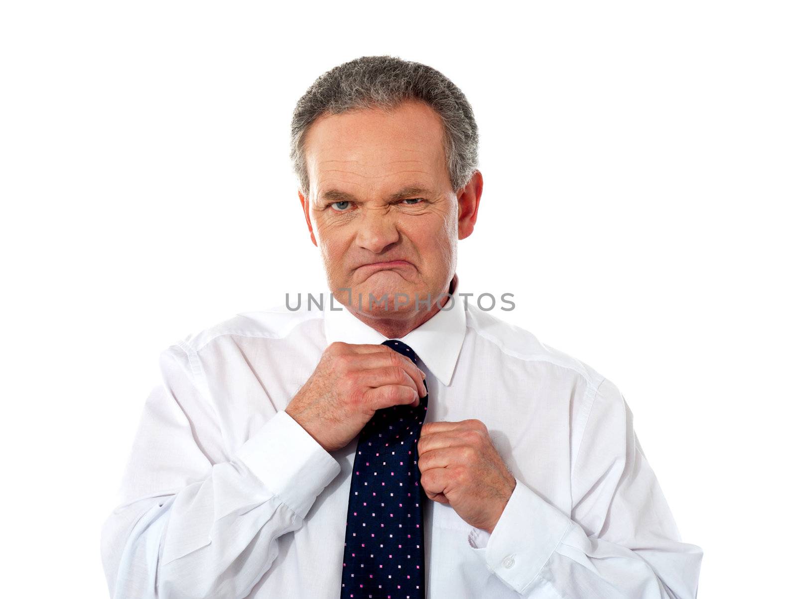 Serious businessman adjusting his tie, irritation on his face