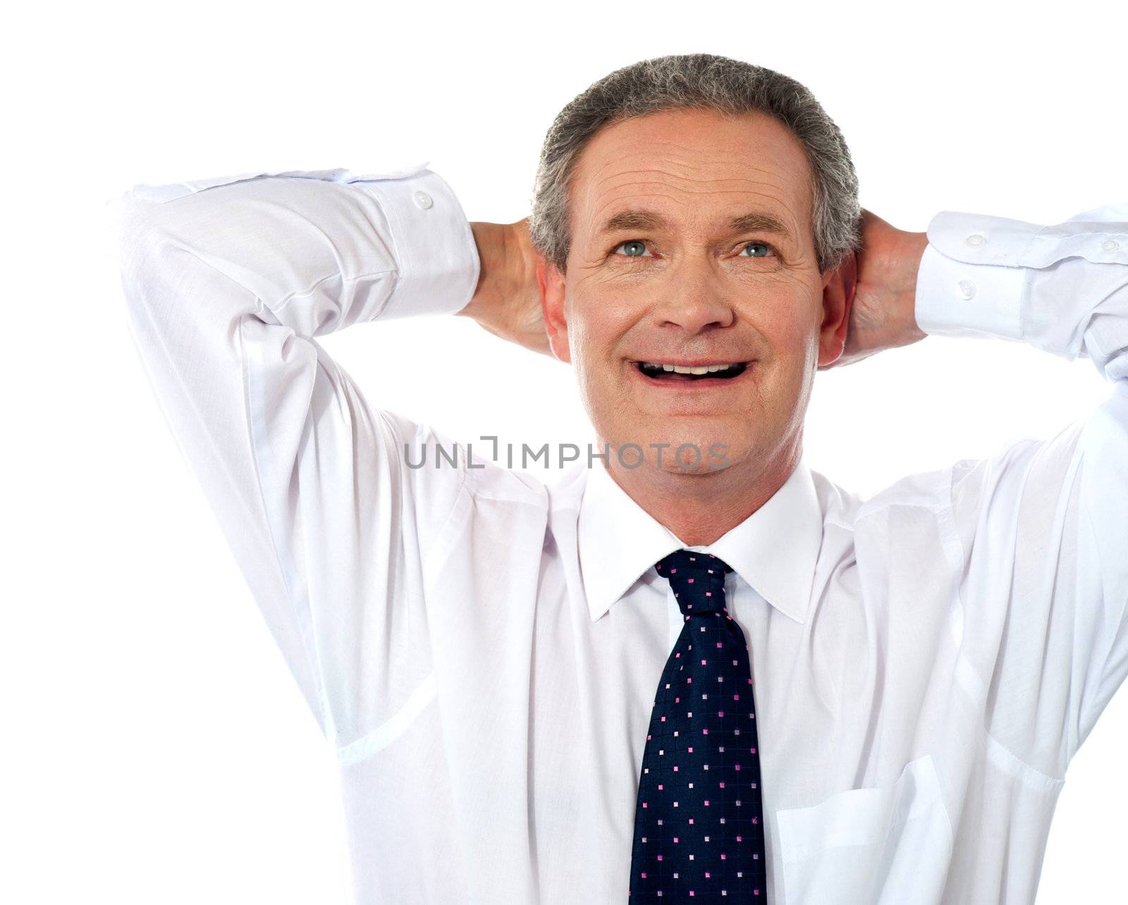 Relaxed aged businessman dreaming with hands at the back of his head