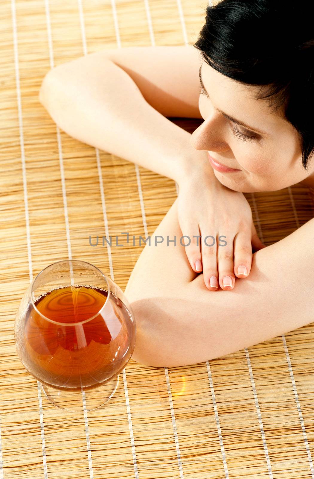 Spa woman relaxing with a wine glass beside her. Spa enviroment