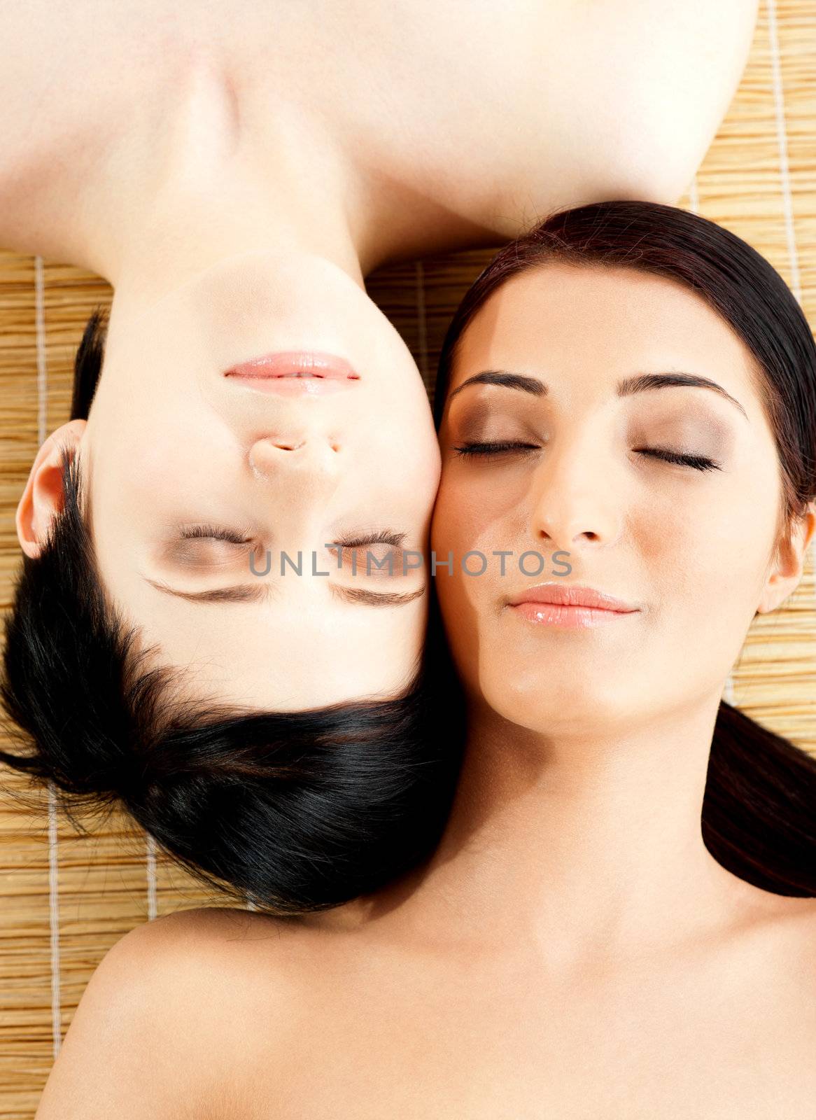 Massage of two beautiful females in spa salon by stockyimages