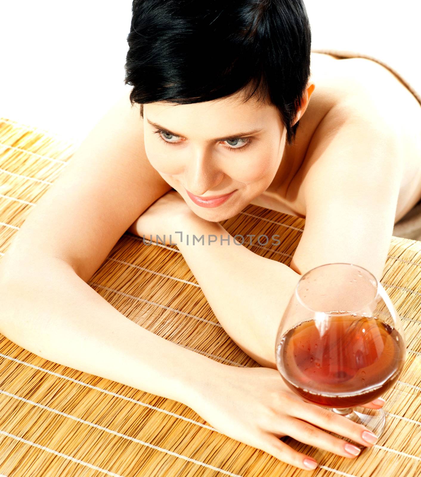 Spa woman hodling wine glass. Relaxing on wooden carpet