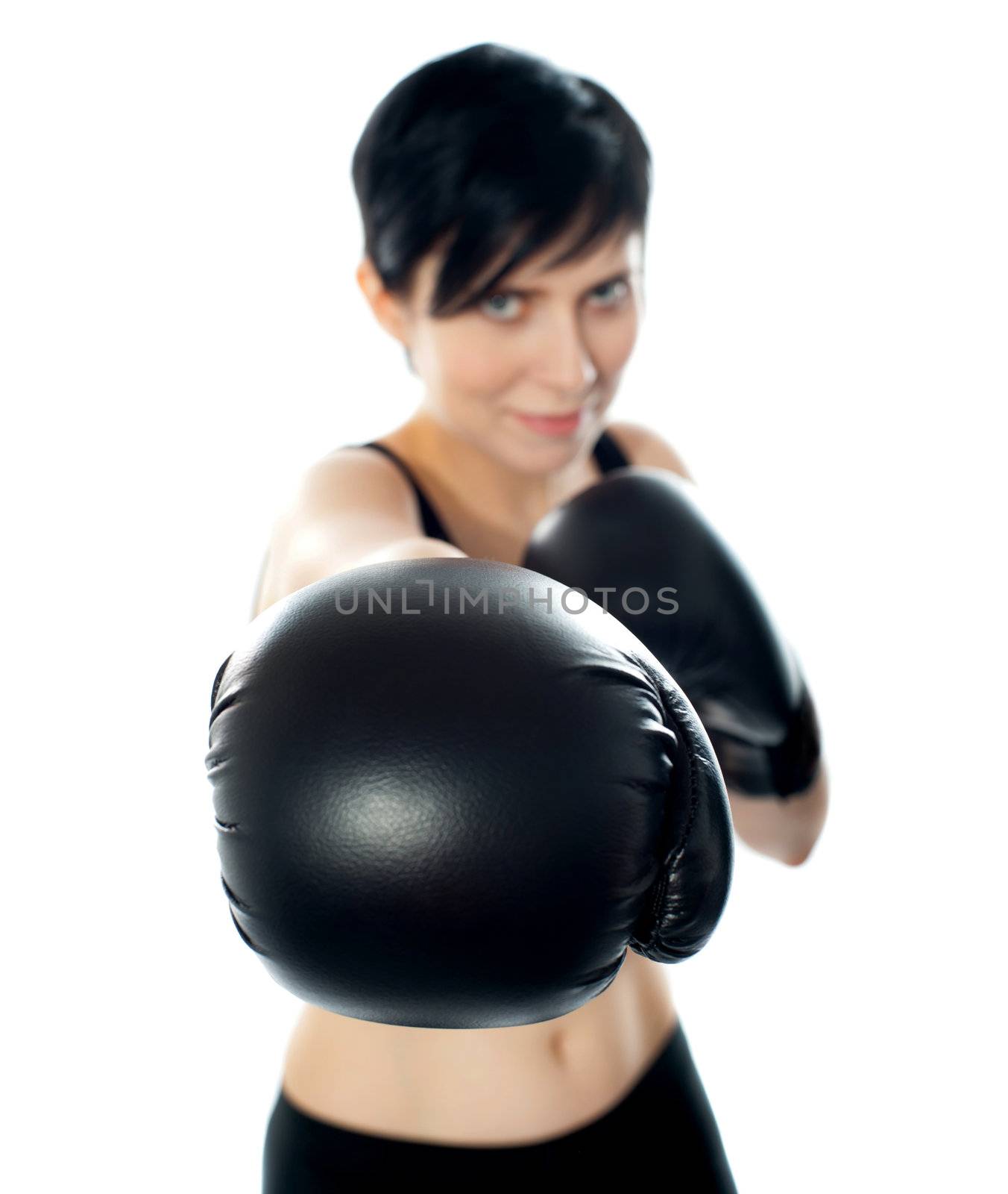 A female wearing black boxing gloves throwing a punch towards camera