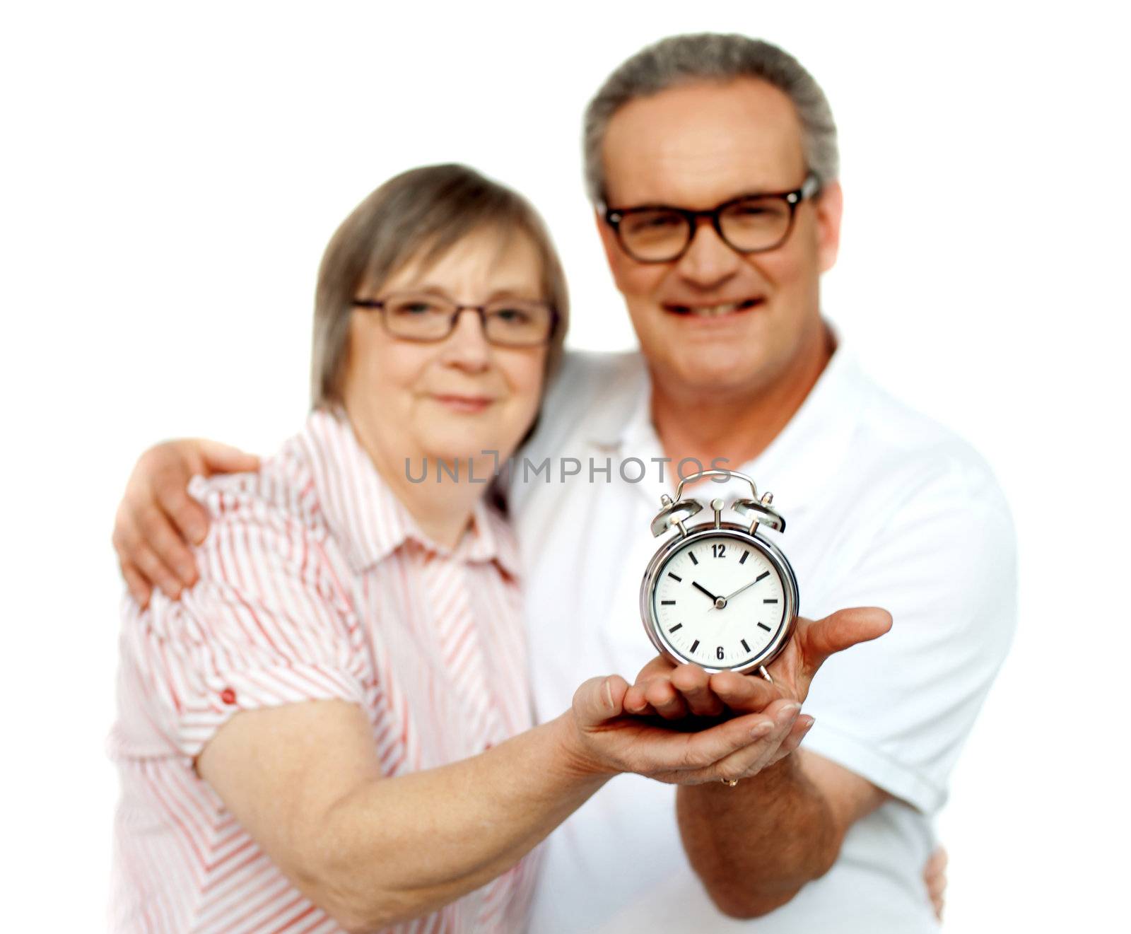 Aged couple with alarm clock on palm isolated over white