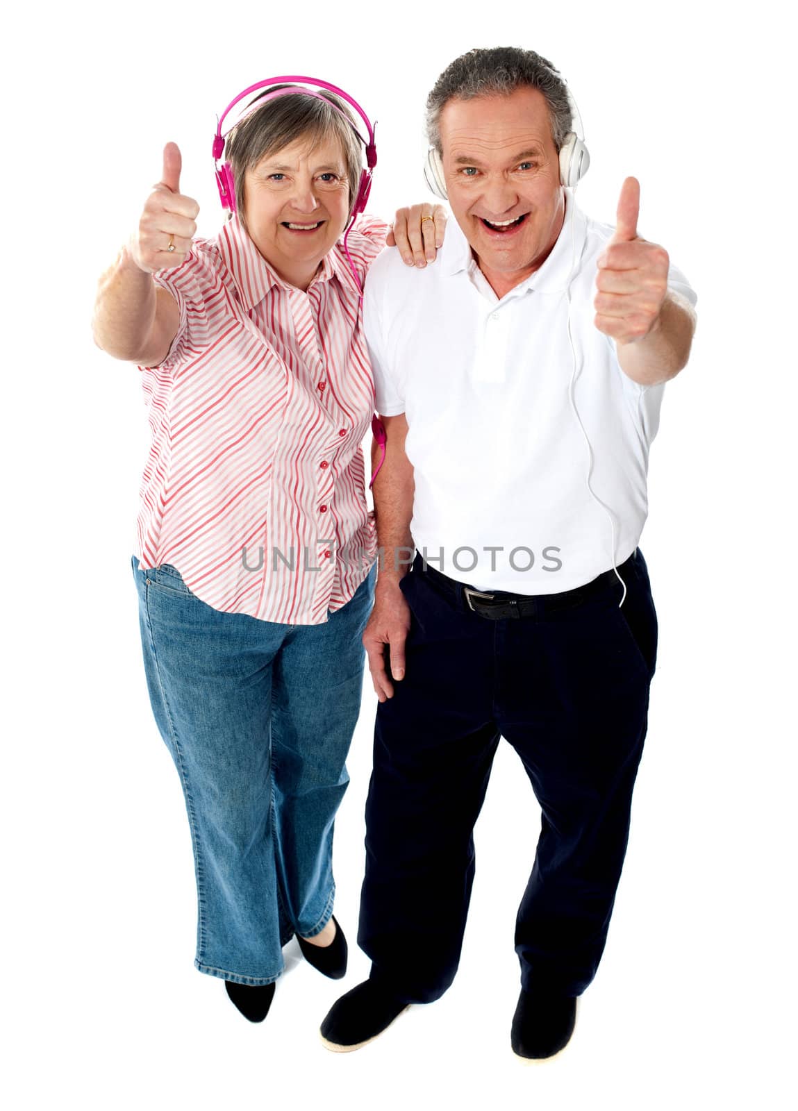 Thumbs-up couple tuned into music, isolated over white