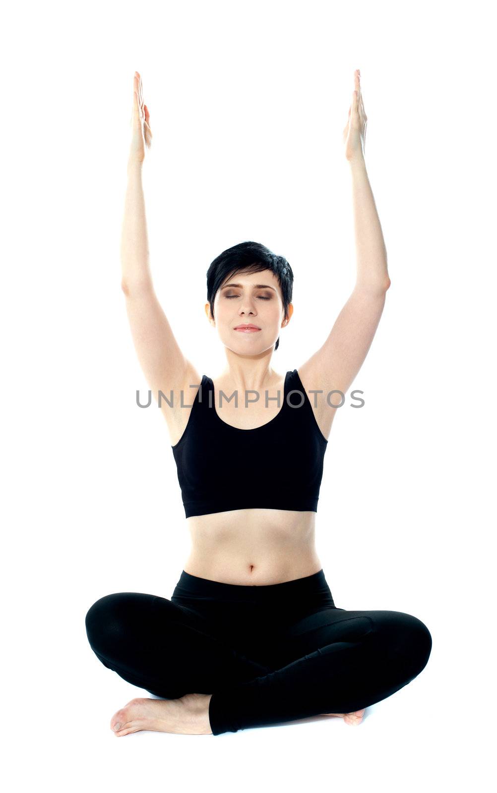 Portrait of beautiful young woman doing yoga exercise. Arms raised