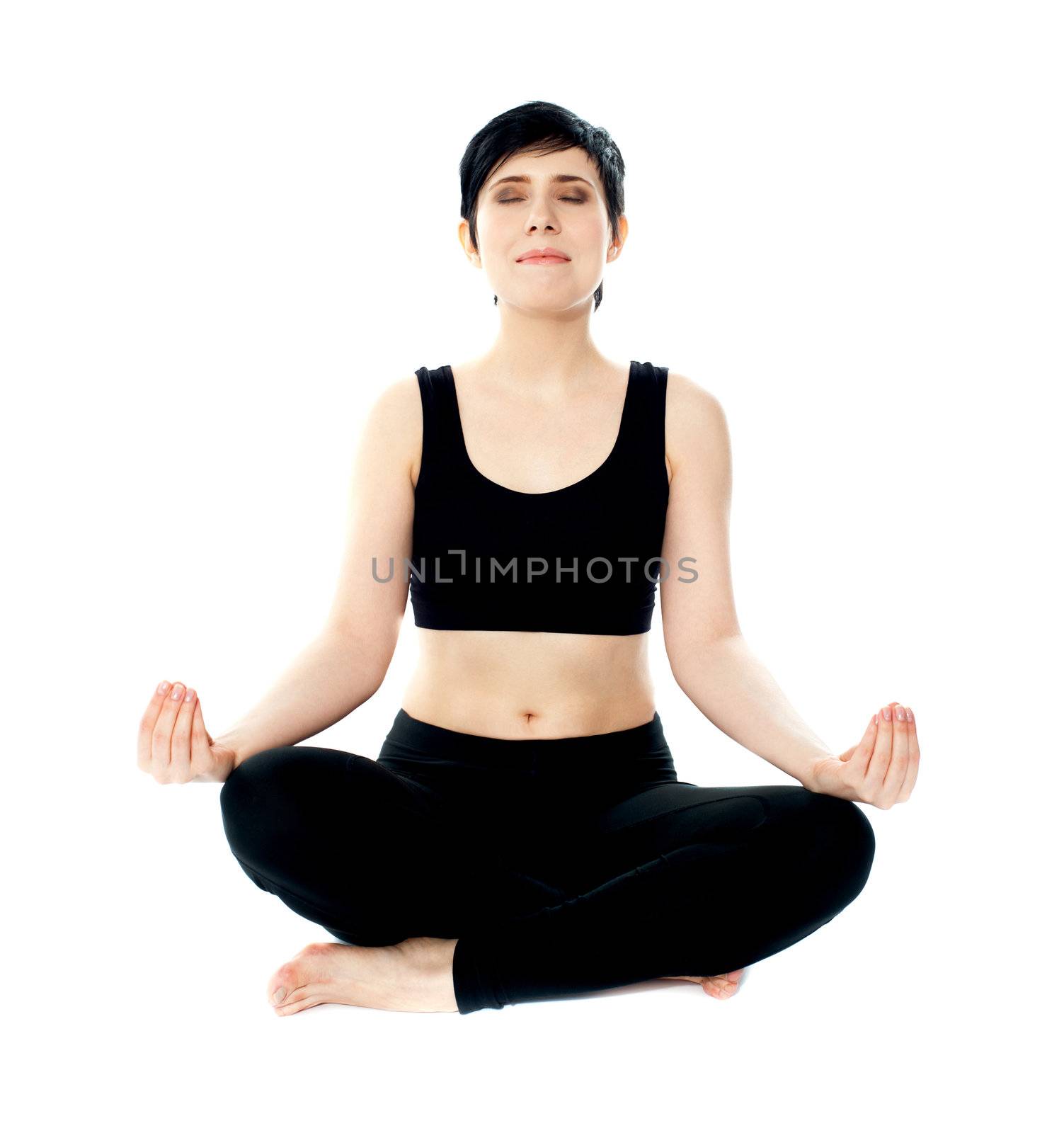 Portrait of young woman meditating in lotus pose