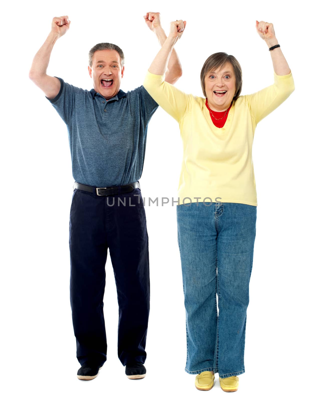 Excited senior couple. Arms raised by stockyimages