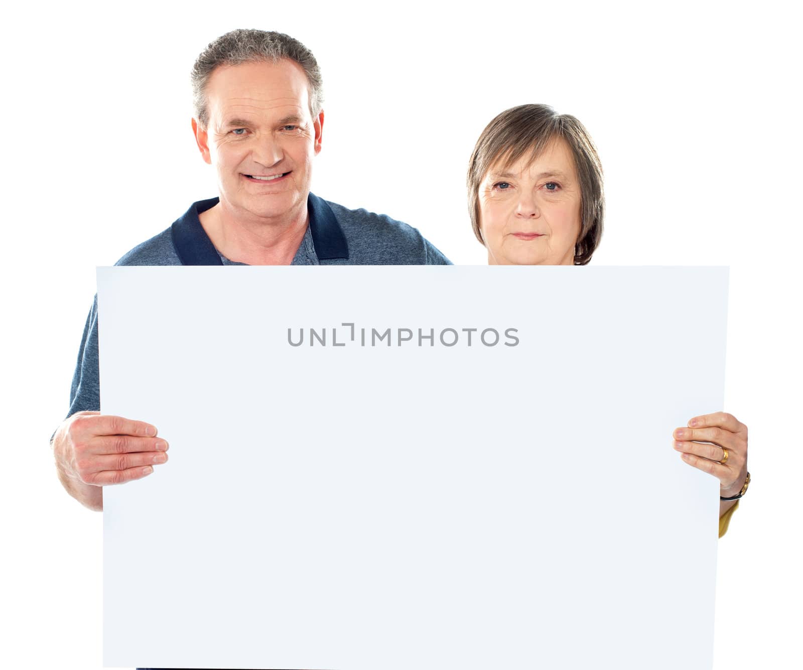 Smiling aged couple displaying blank banner against white background
