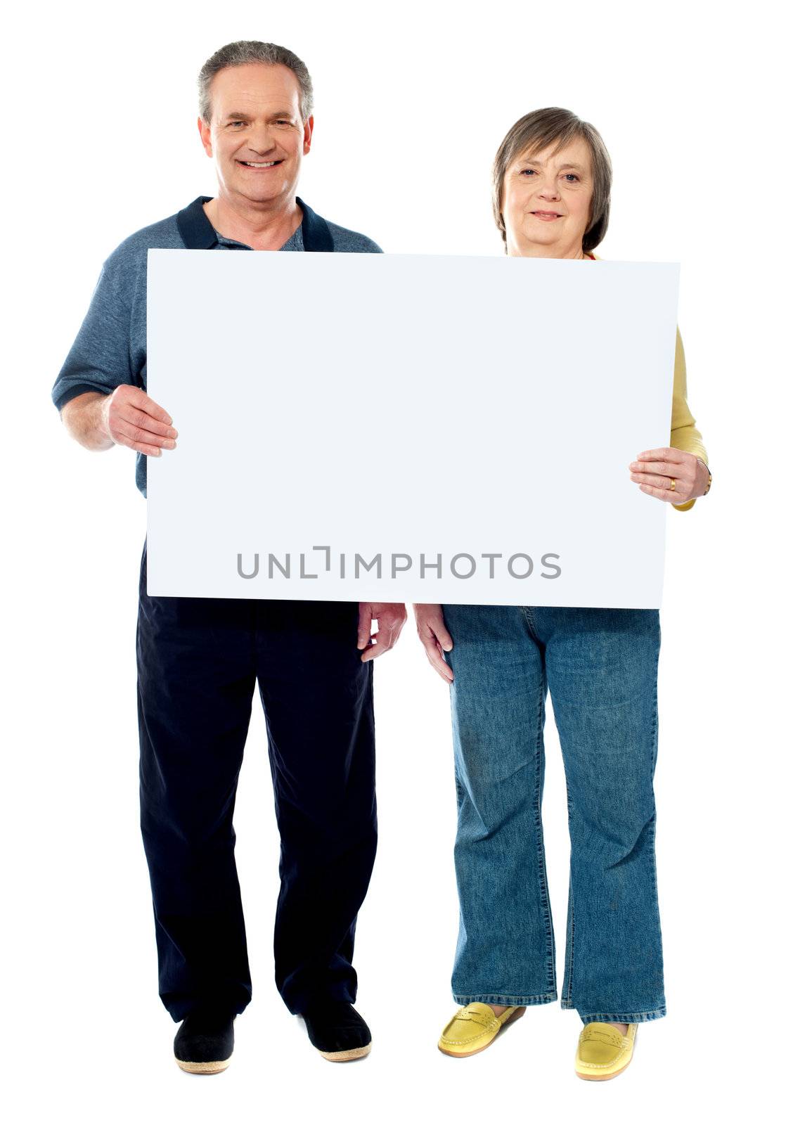 Happy senior couple holding a white placard. Full length portrait