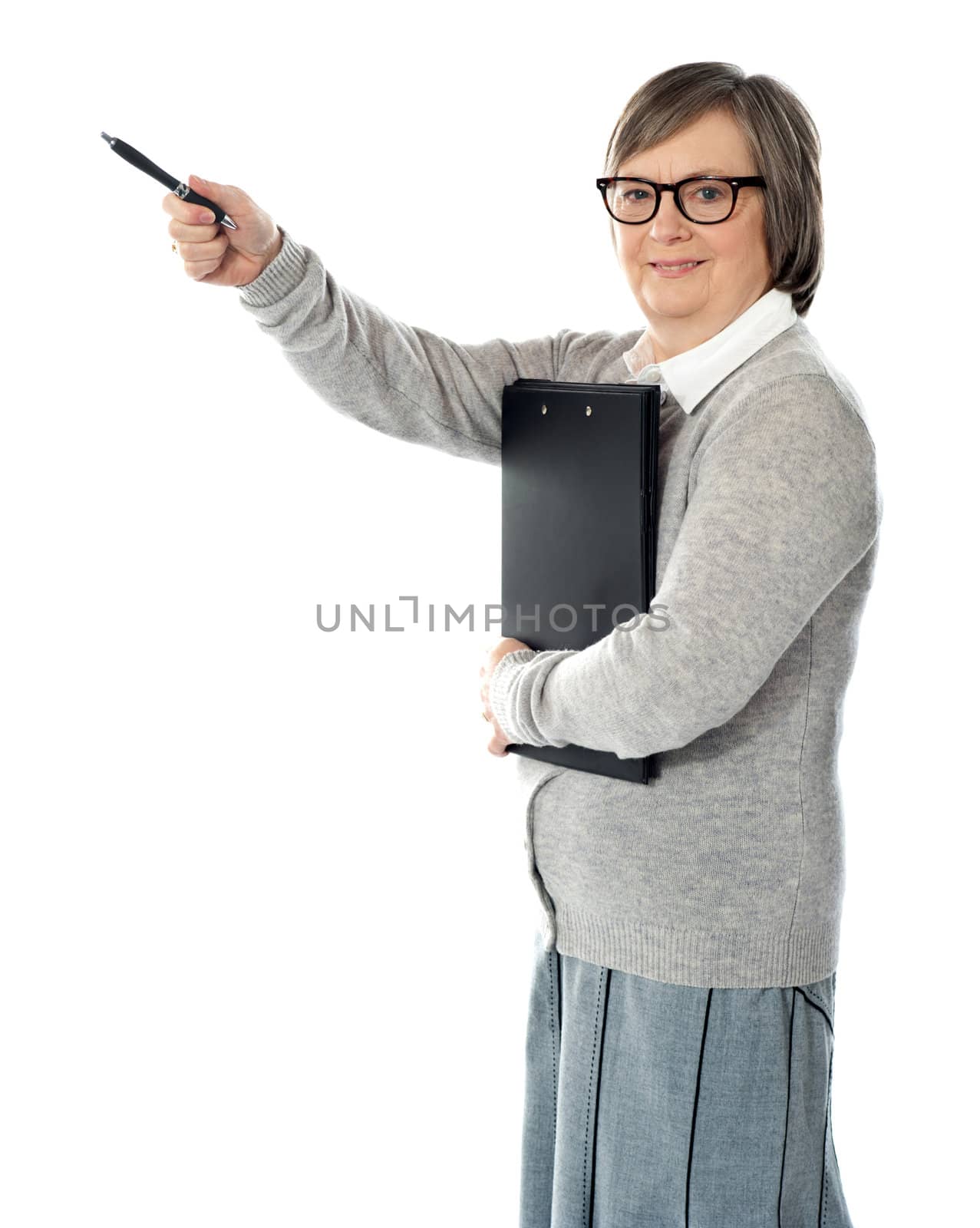 Female executive pointing away with pen in hand. Carrying business documents
