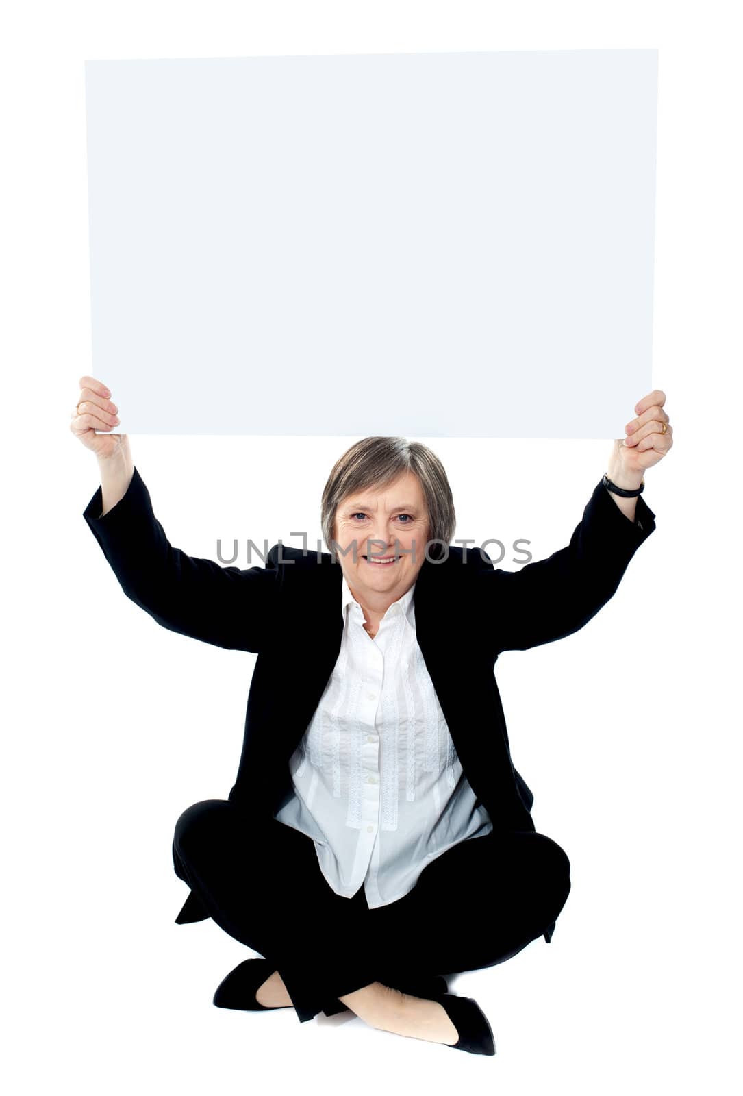Seated businesswoman holding blank whiteboard over her head