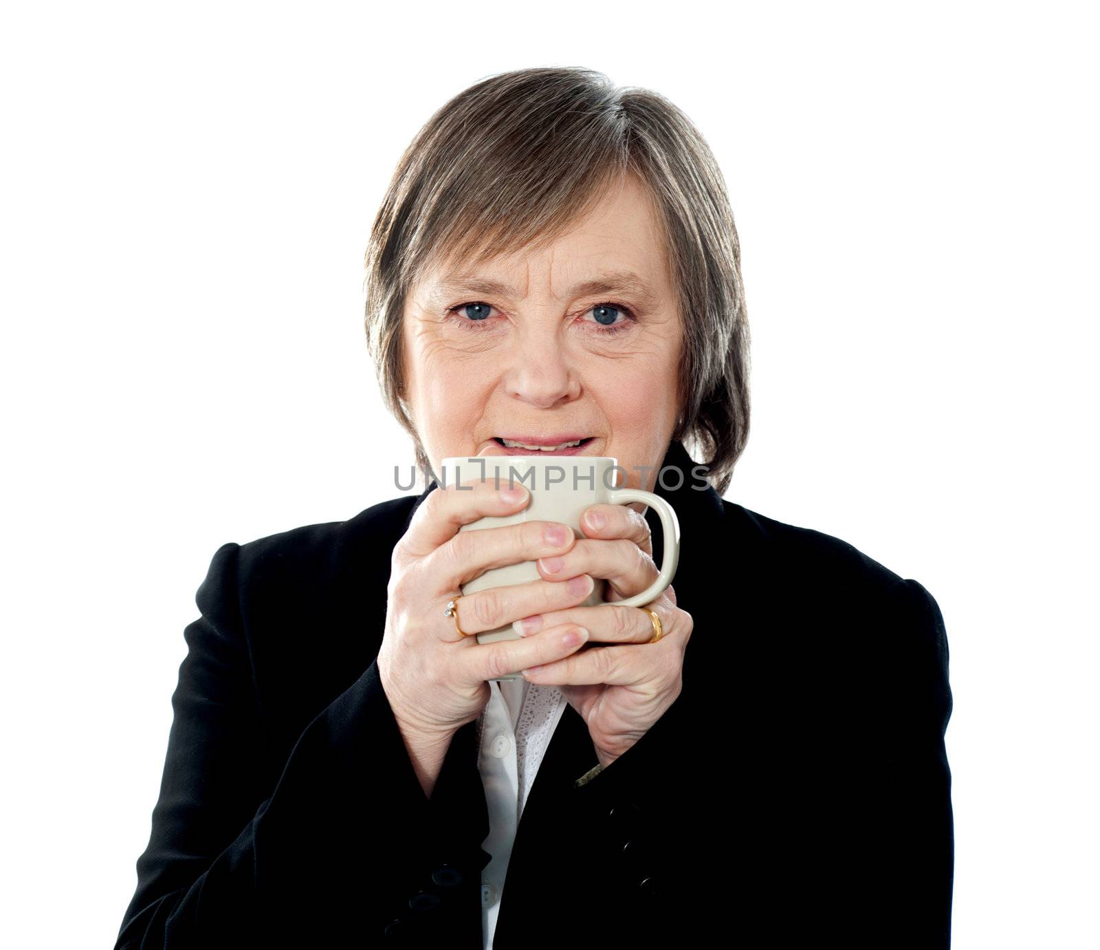 Old woman holding coffee mug, sipping hot coffee