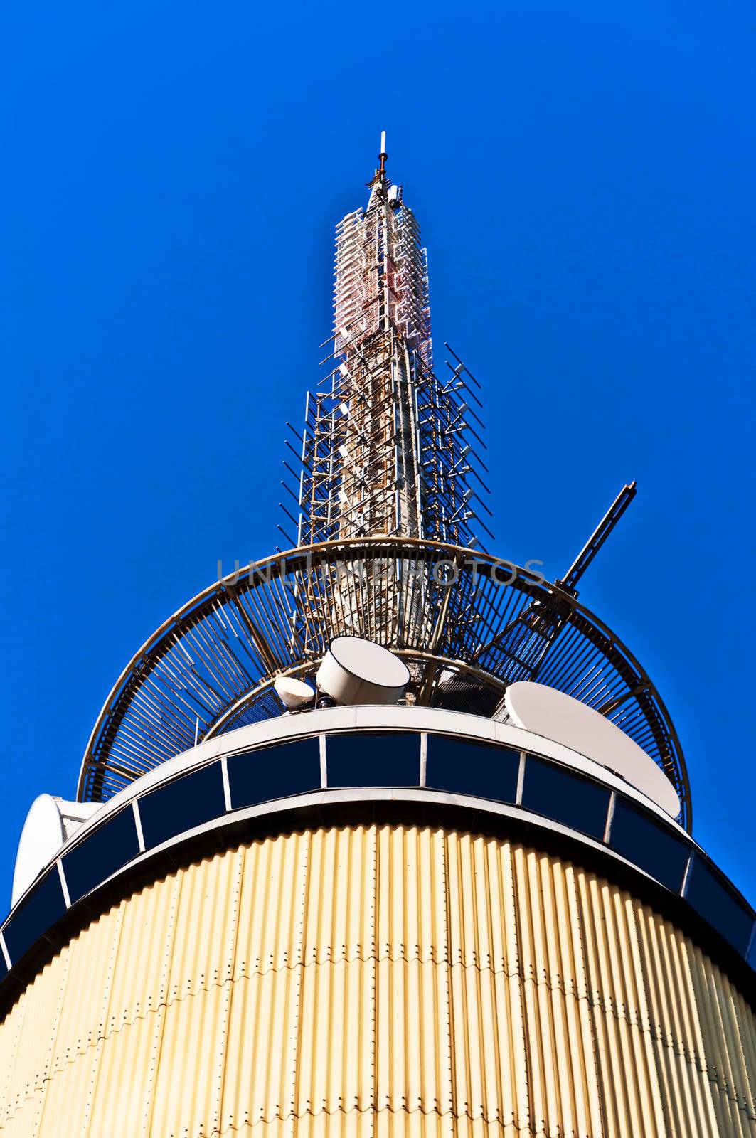 Telecom tower with microwave links and cellular network antennas on blue sky Oslo Norway