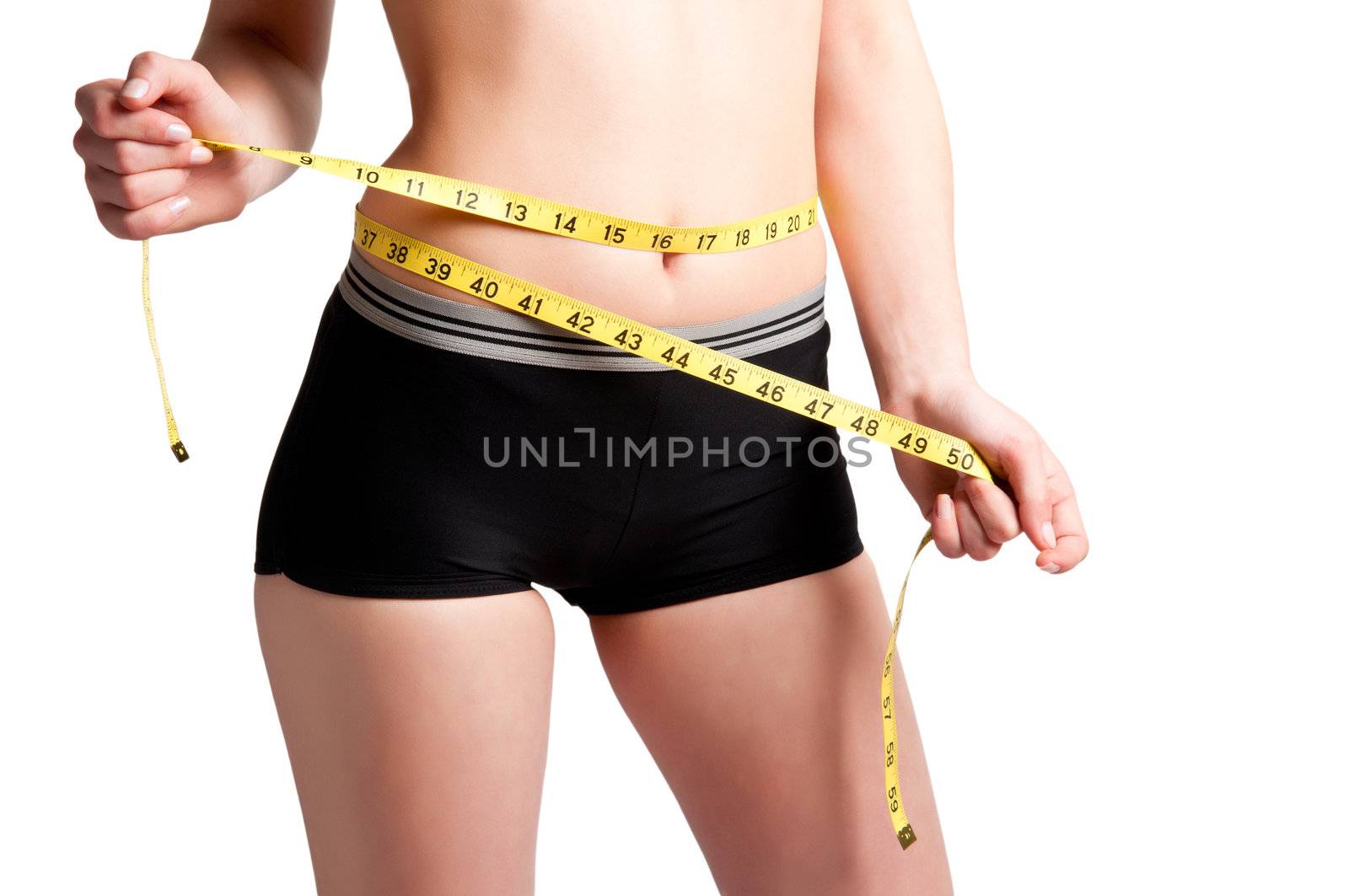 Woman measuring her waist with a yellow measuring tape