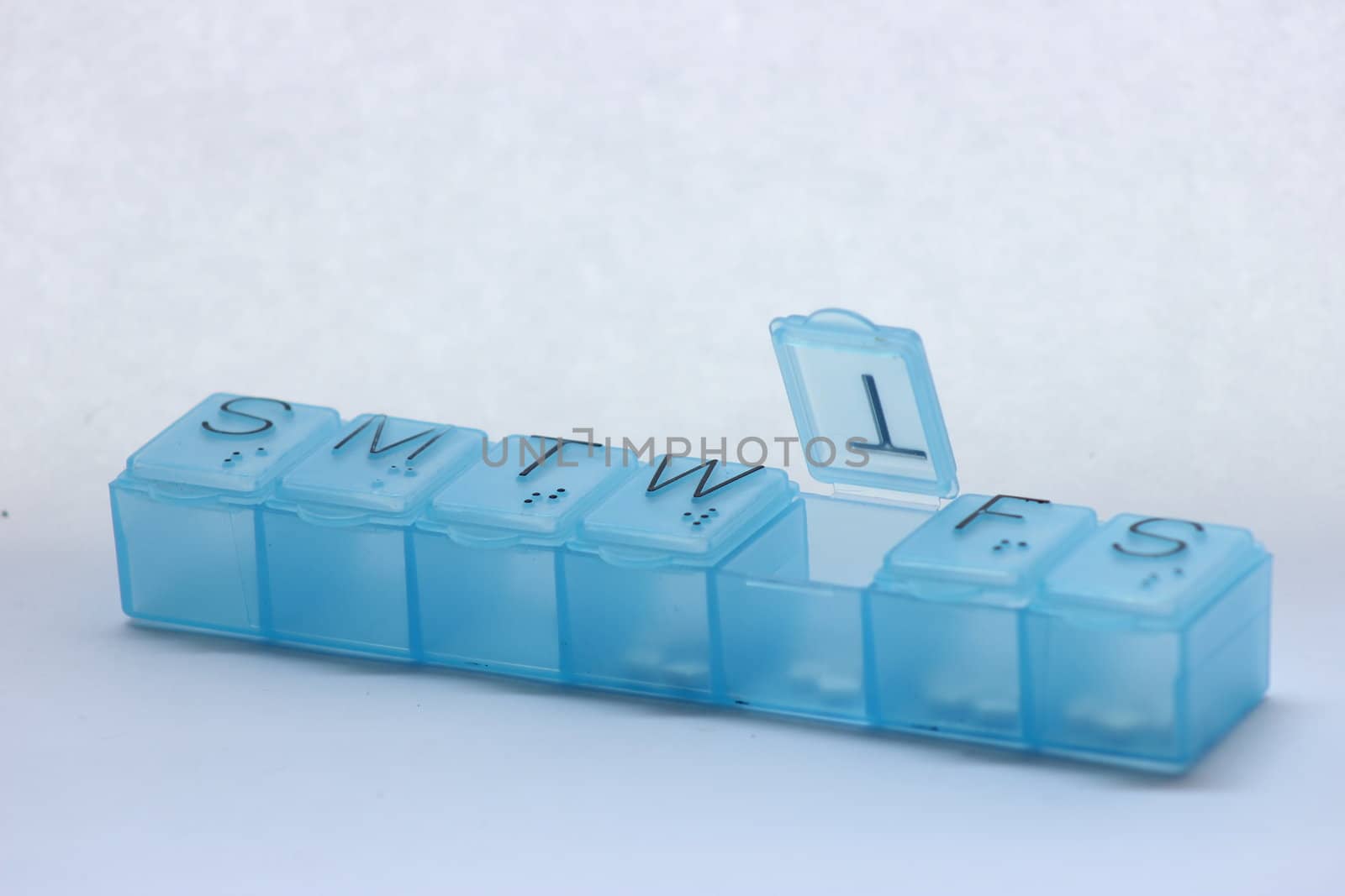 7 day pill box with open tab with medication
