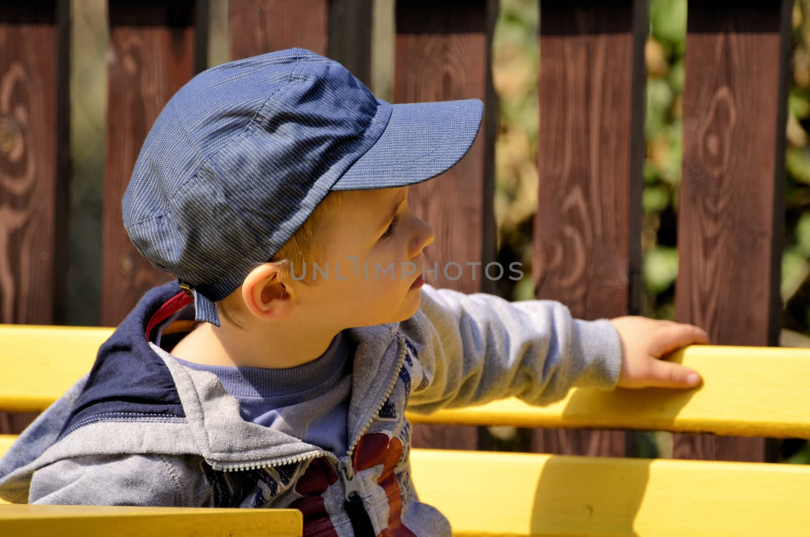 The photo shows a little boy whose very interested in something and keeping a watchful eye.