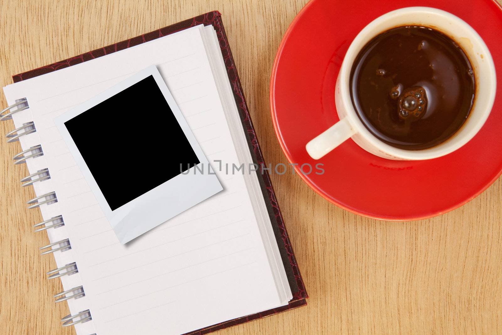 cup coffee and photo frame and notebook on wood background