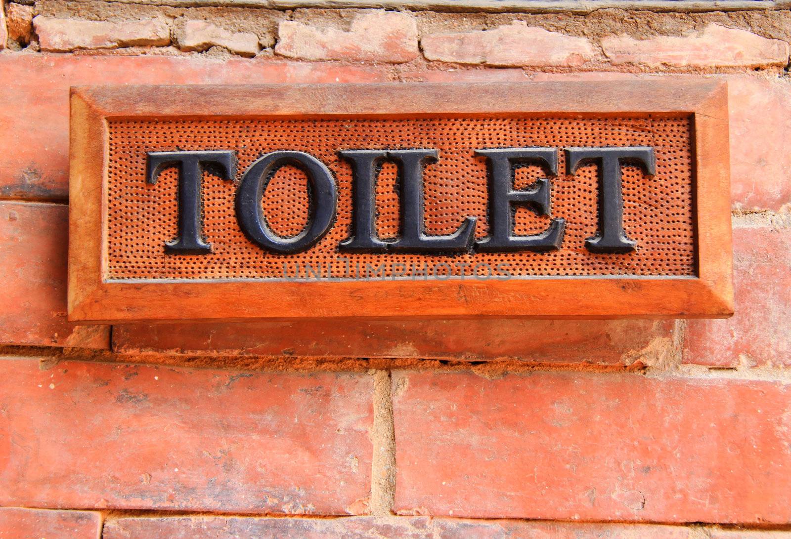 Ancient toilet sign on brick wall by nuchylee