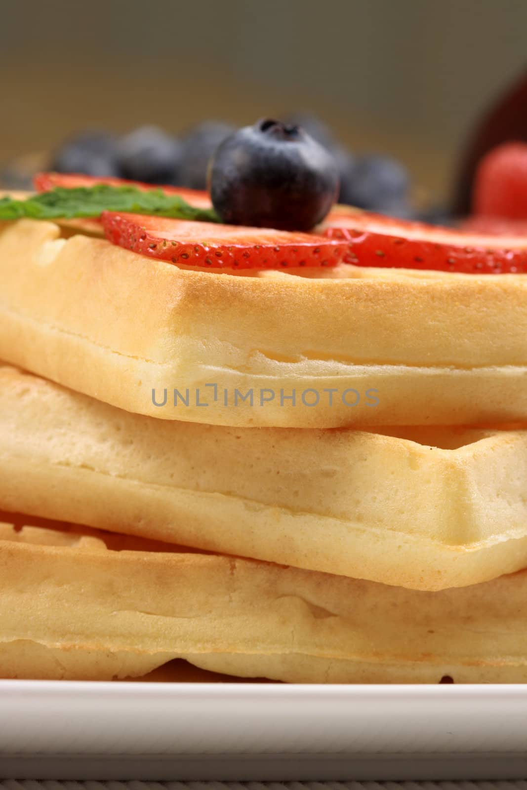 Exquisite belgian waffle garnished with organic strawberry and blueberry