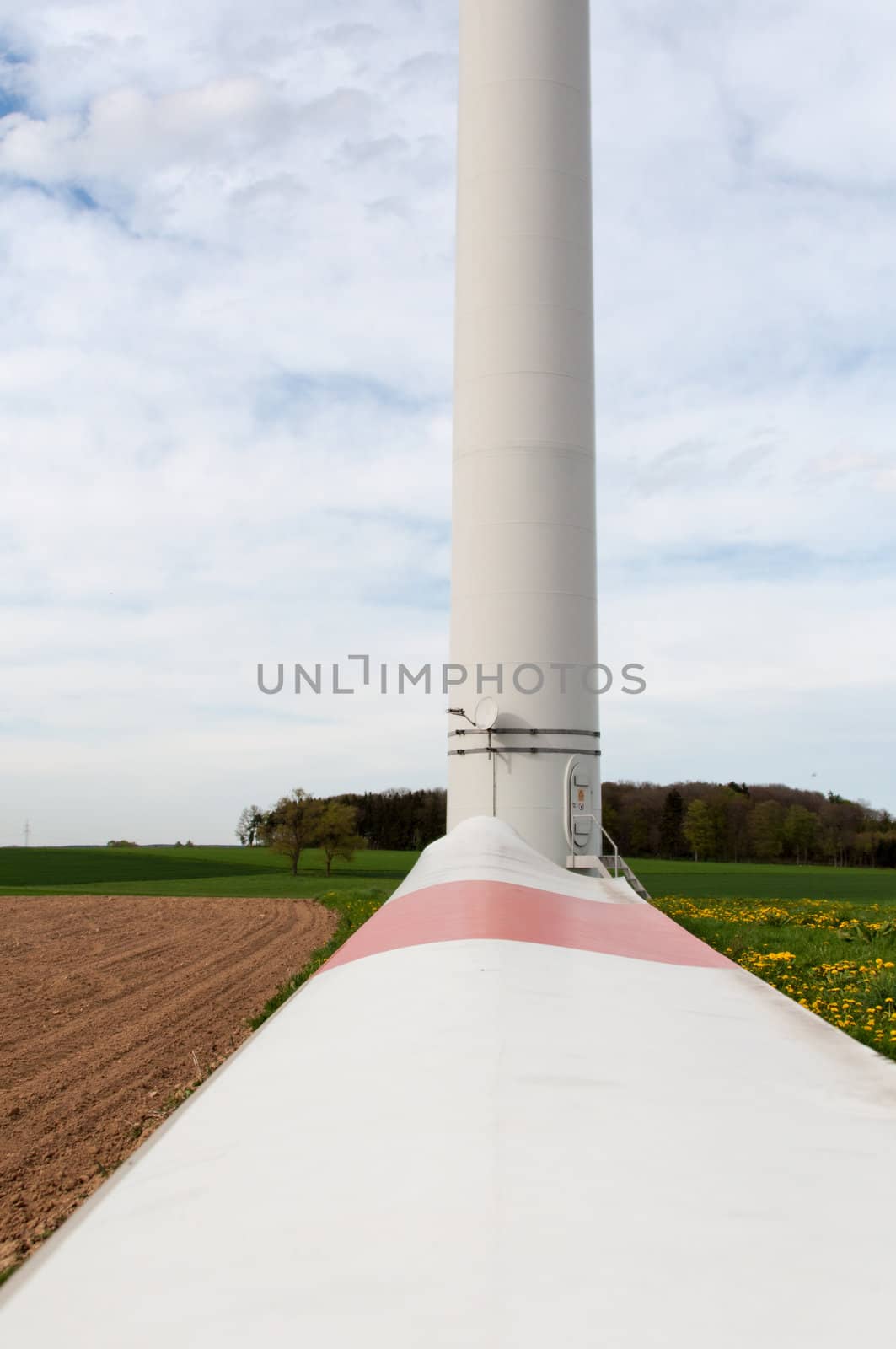 alternative energy source. wind turbine with spare rotor blade lying in front