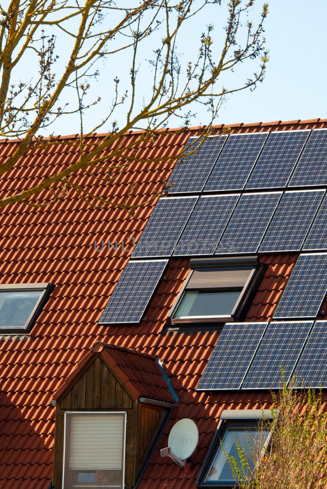 Solar panels on a red roof of a modern building
