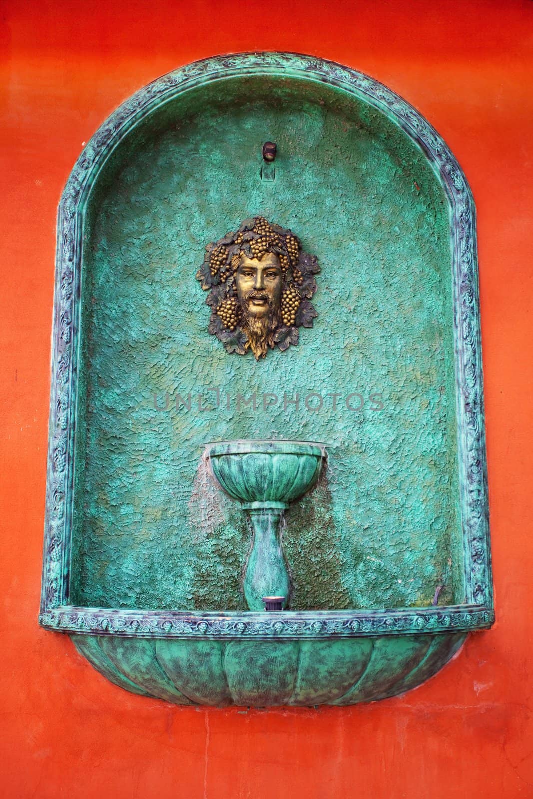 A head water fountain on red wall