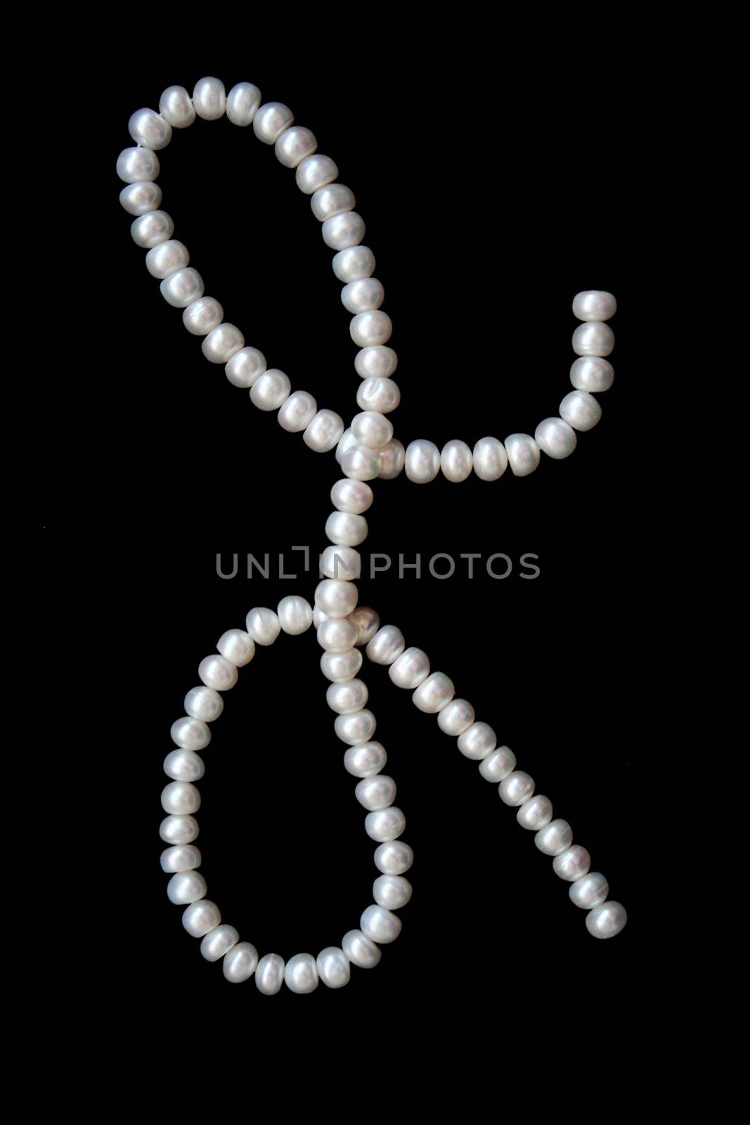 White pearls on the black velvet background 