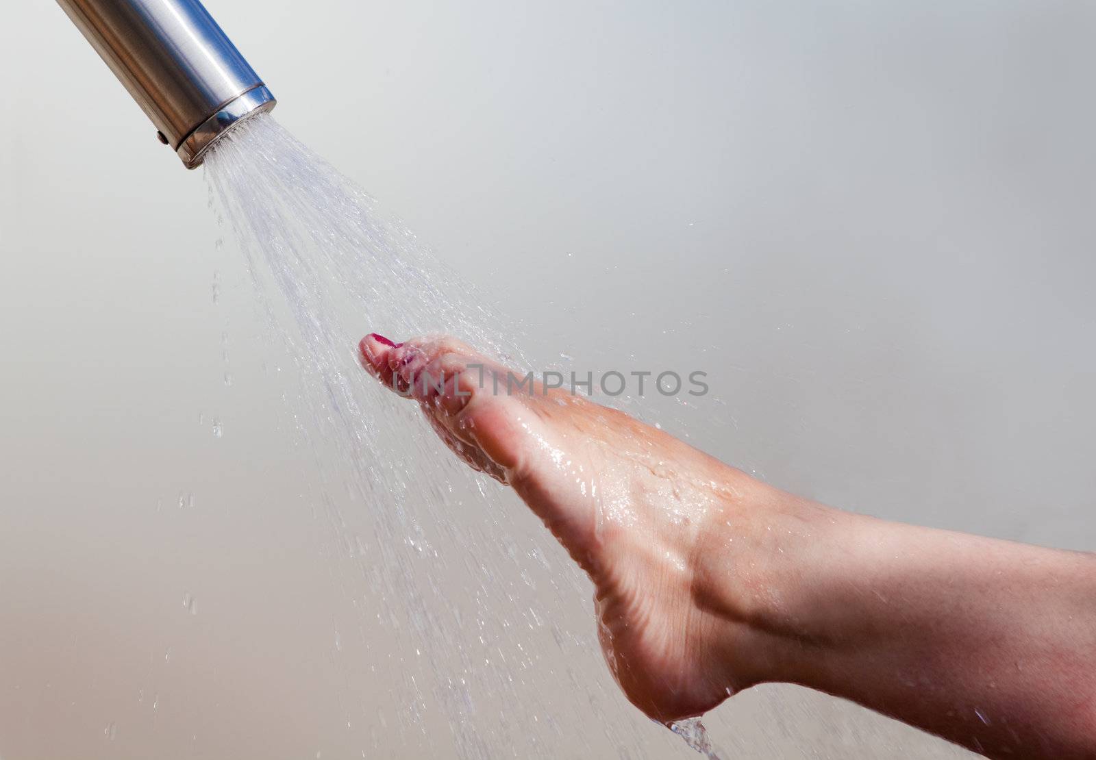 Detail of a girl's foot and water jet