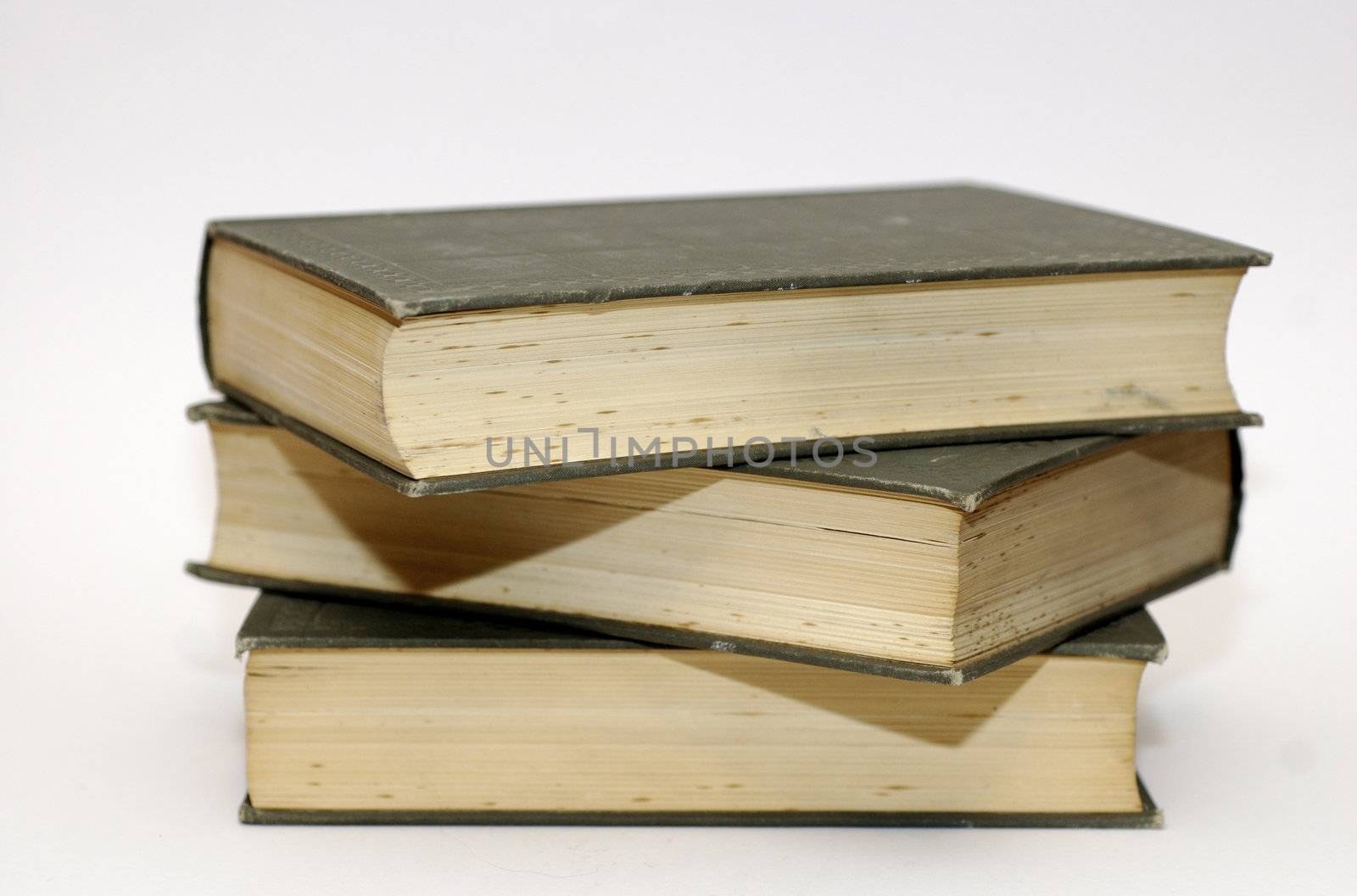 Pile of three leather bound, old fashioned, books against a white background and copy space