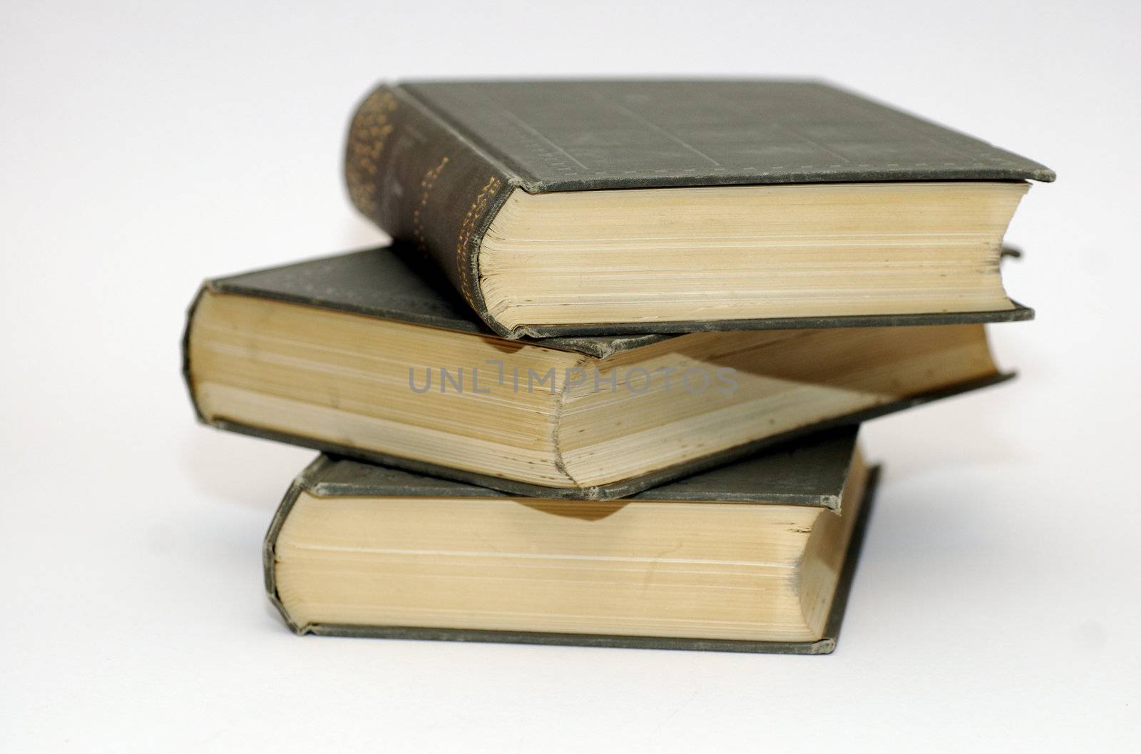 Pile of three leather bound, old fashioned, books against a white background and copy space