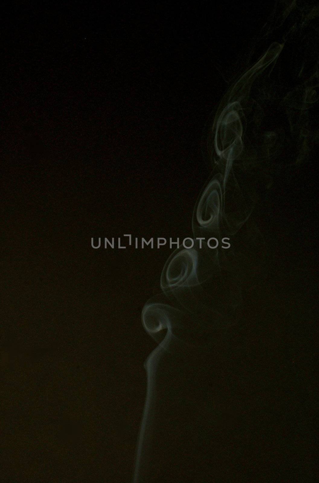 Rising white smoke plume against black background, featuring whirls, whorls and swirls with copy space.