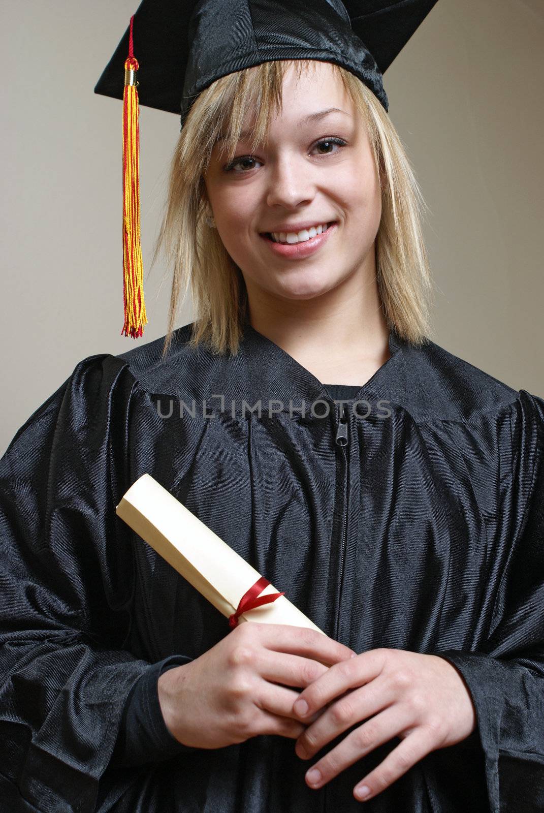 A happy graduate in her gown and mortarboard.