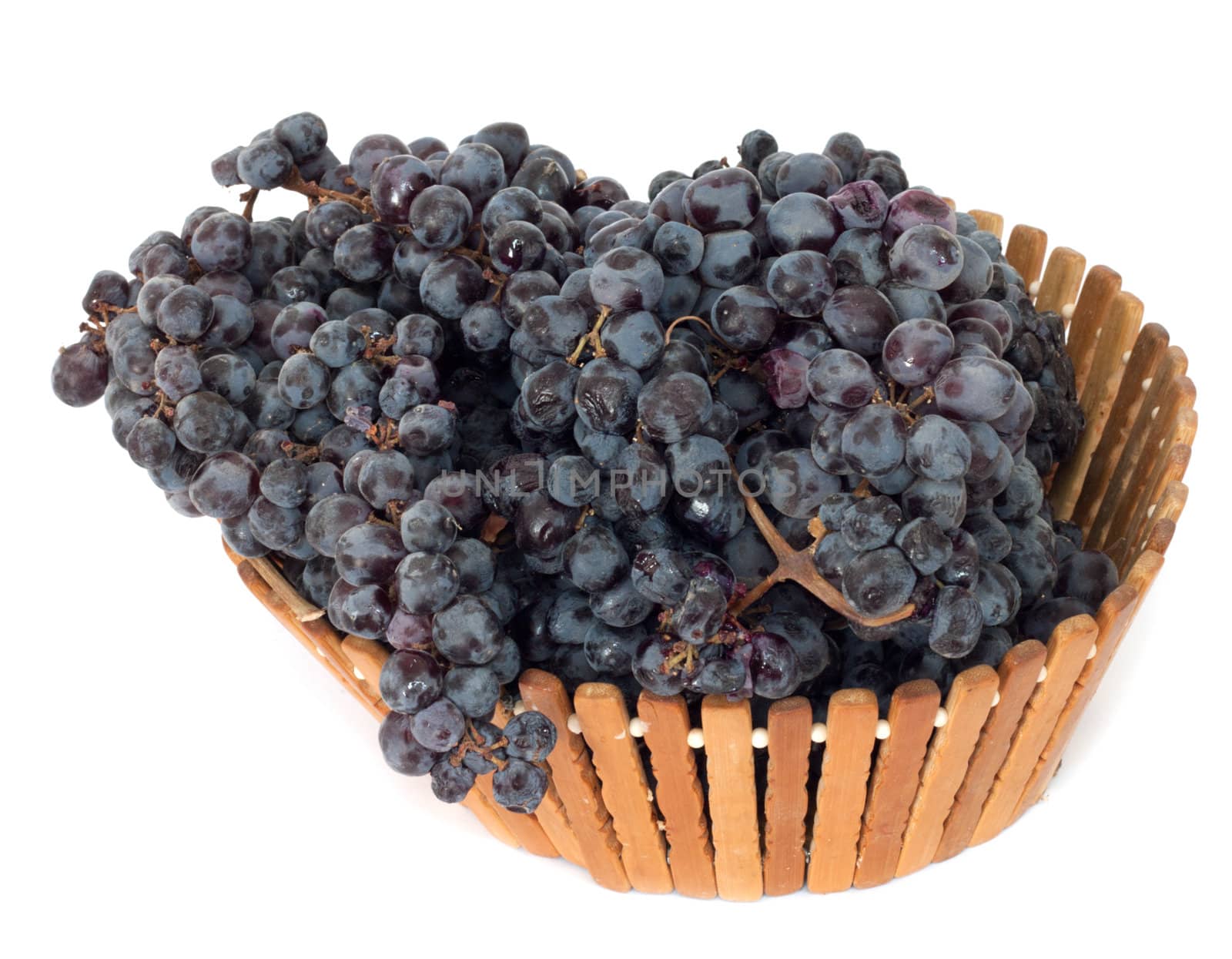 black grapes in a basket on a white background